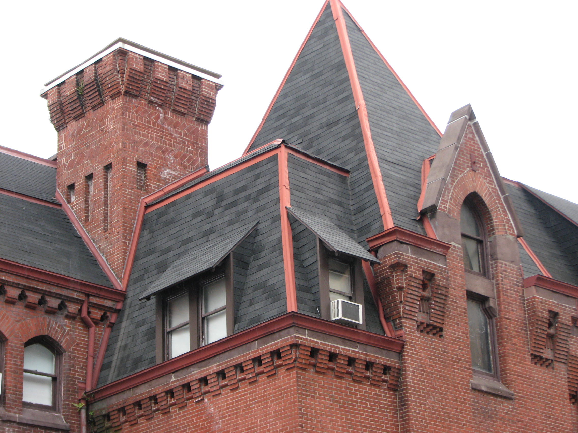 Pitched roofs, gables, dormers, and corbelled chimneys adorn the sections designed by Furness.
