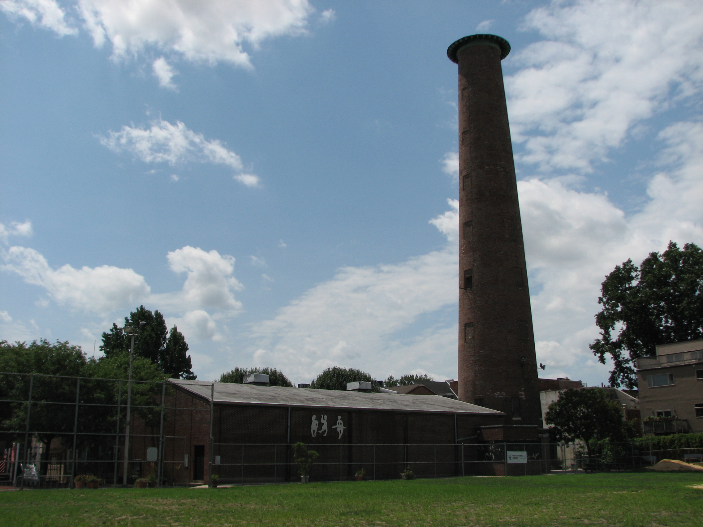 The low brick rec center huddles at the base of the tower.
