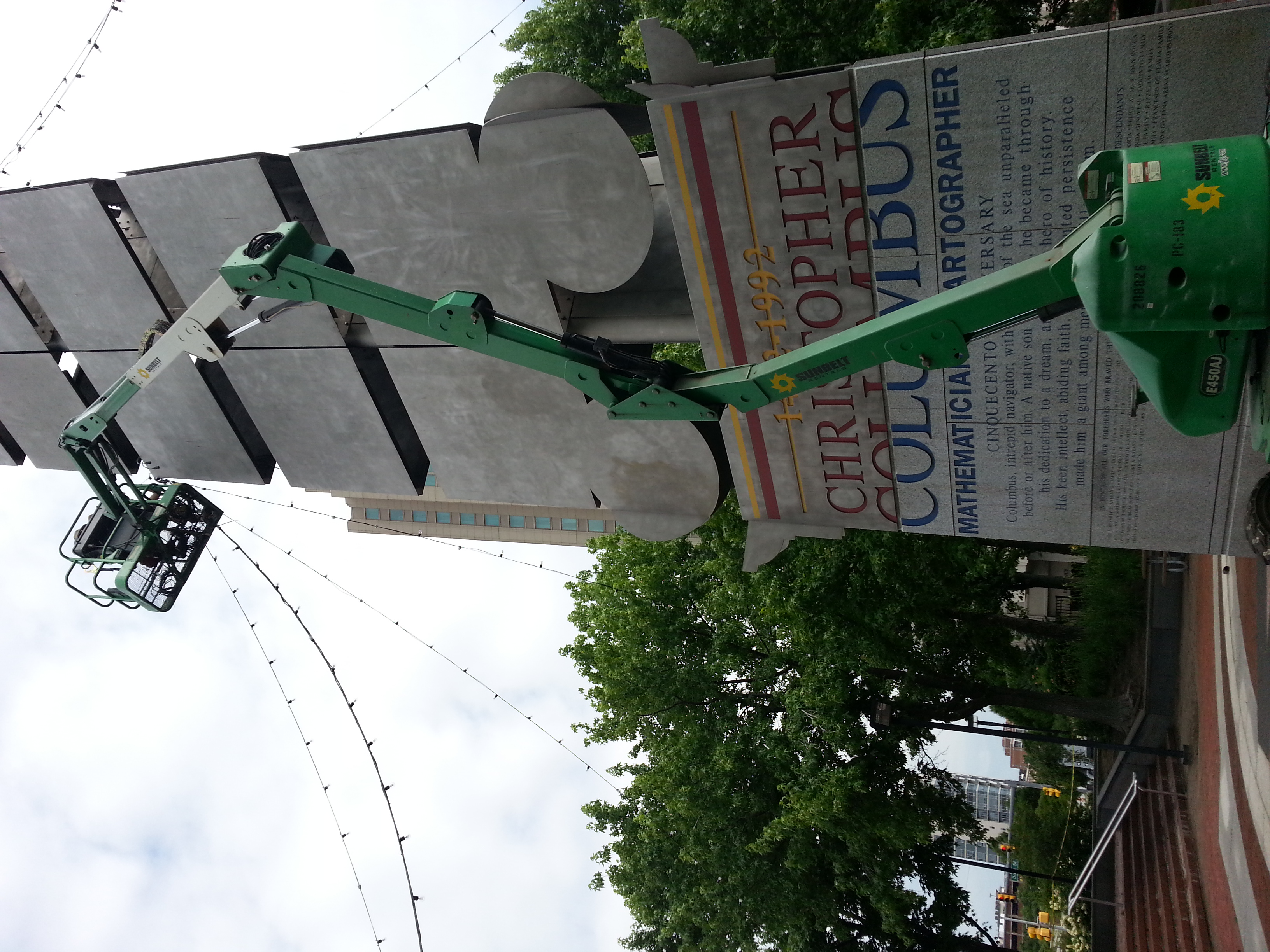 Market lights being strung at the Christopher Columbus monument for Spruce Street Harbor Park