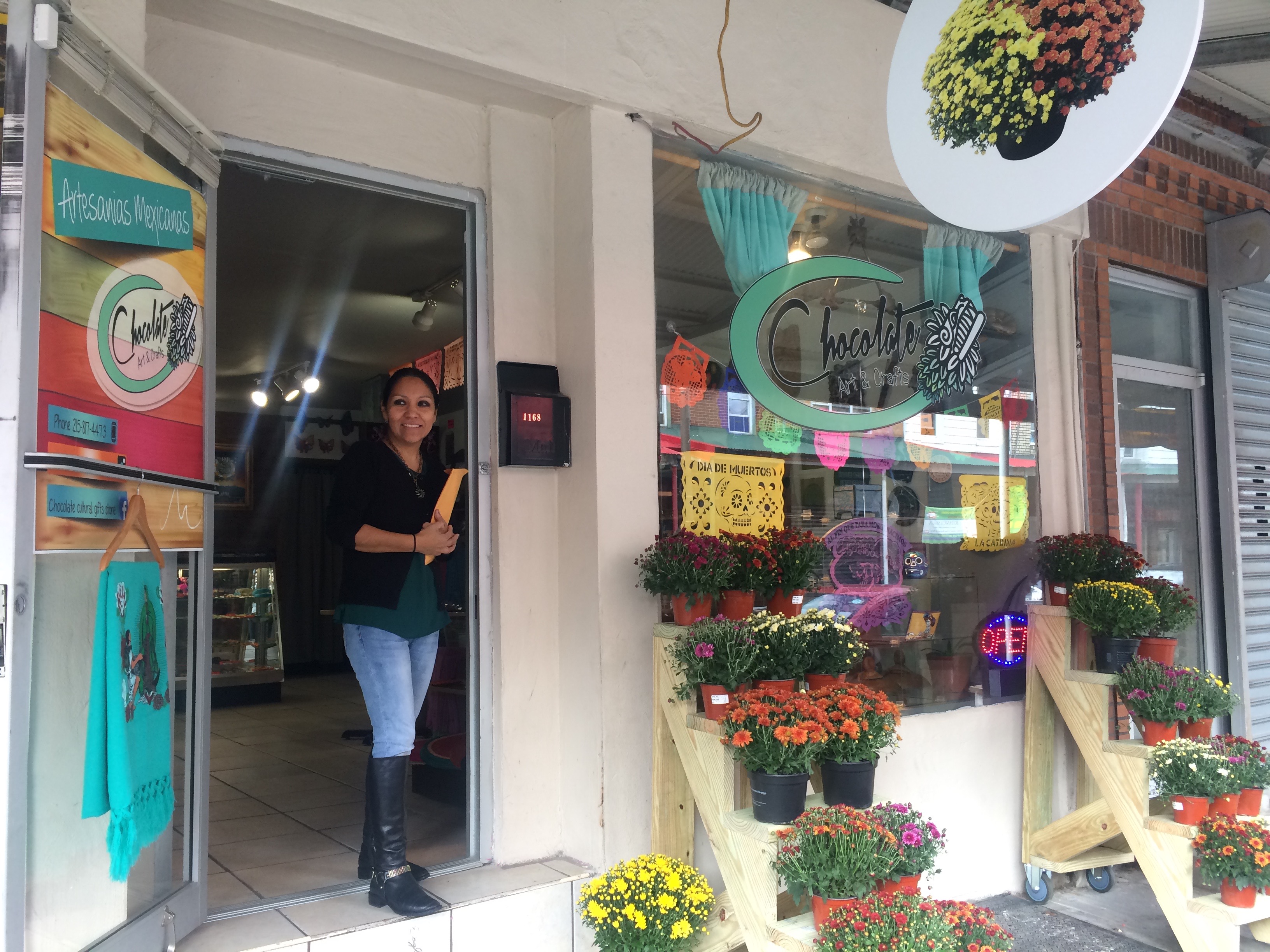 9th Street Stock Exchange: Mums from Betty Ann’s Italian Market Florist outside Chocolate Arts and Crafts. Owner Eva Hernández at the door. | Catalina Jaramillo