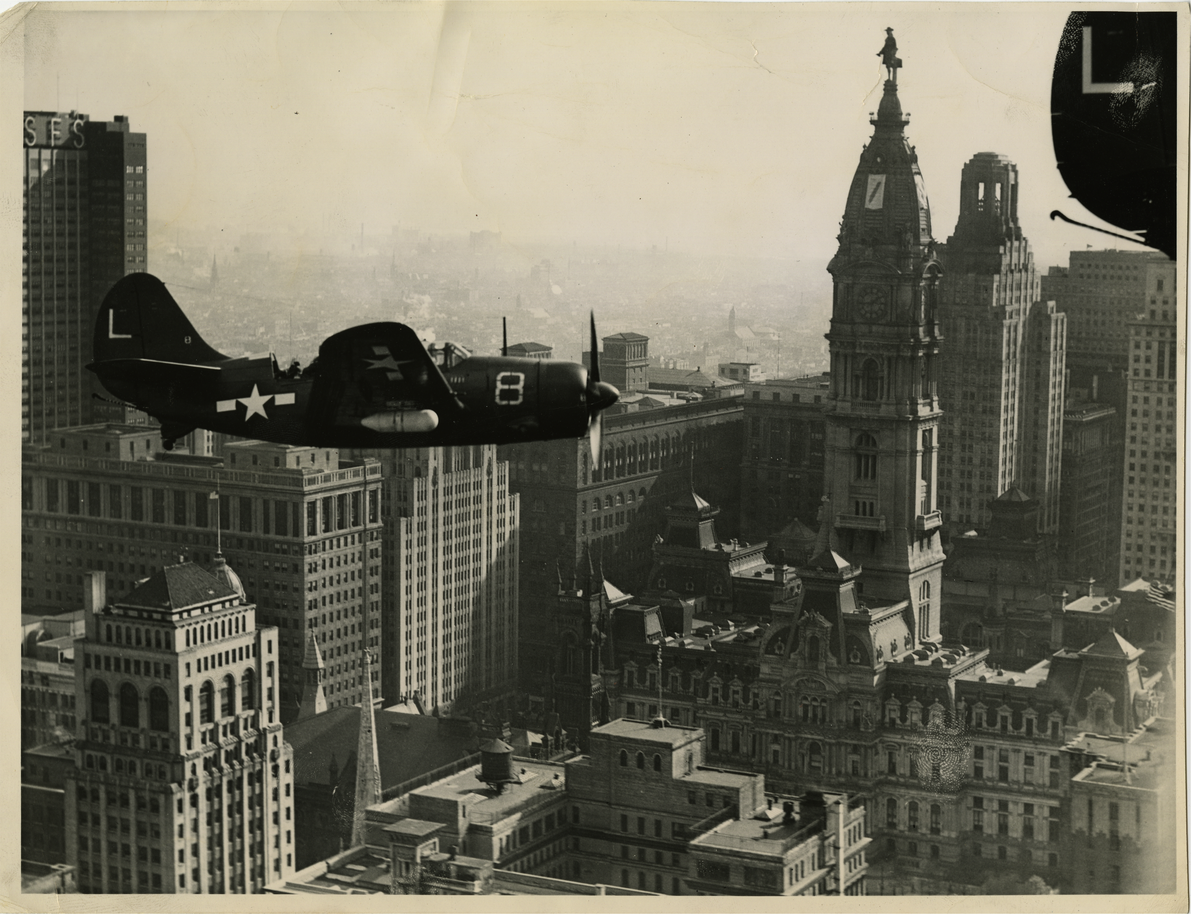 Planes fly in front of City Hall Record Number: 3181Collection: Philadelphia Record Photograph Morgue [V07], Folder Number: FF 33.2248 Reproduction restrictions: Unknown Address: North Broad Street, Philadelphia, PA 19107, USA Date of Original: 1945 Photograph depicts aerial view of Curtis SB2C Helldiver’s flying over Philadelphia in front of City Hall.