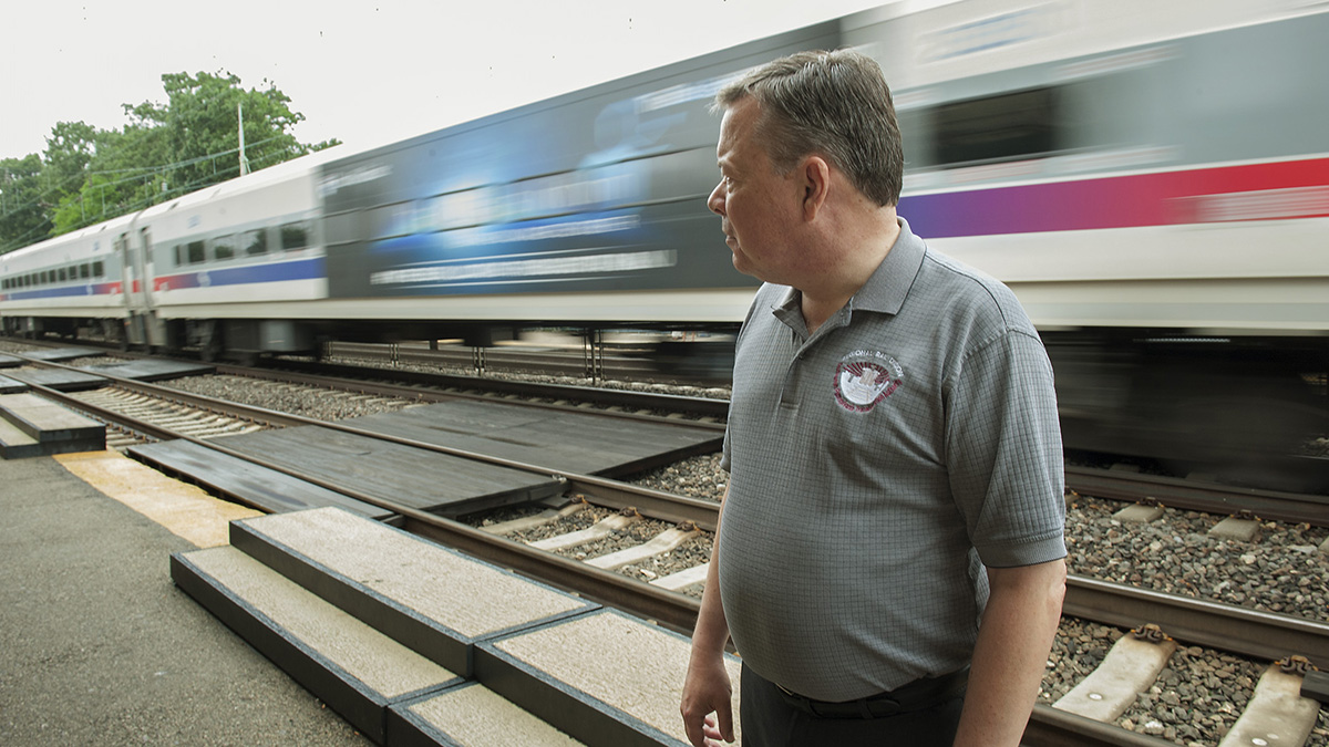 Ardmore Station Ticket Agent Bill Cairns watches a SEPTA train bypass the station. Some trains bypassed the station because they were already full to capacity. (Jonathan Wilson for Newsworks)