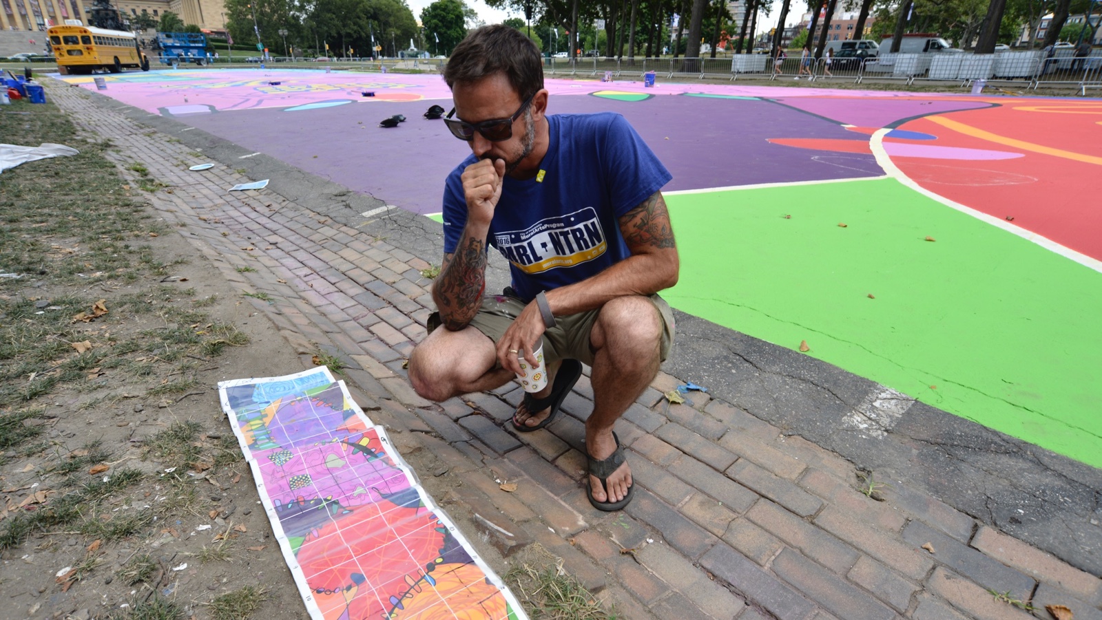 Lead muralist Brad Carney checks the design of his 25,000-square-foot mural 'Rhythm & Hues', that is currently being painted at Eakins Oval. (Bastiaan Slabbers for NewsWorks)