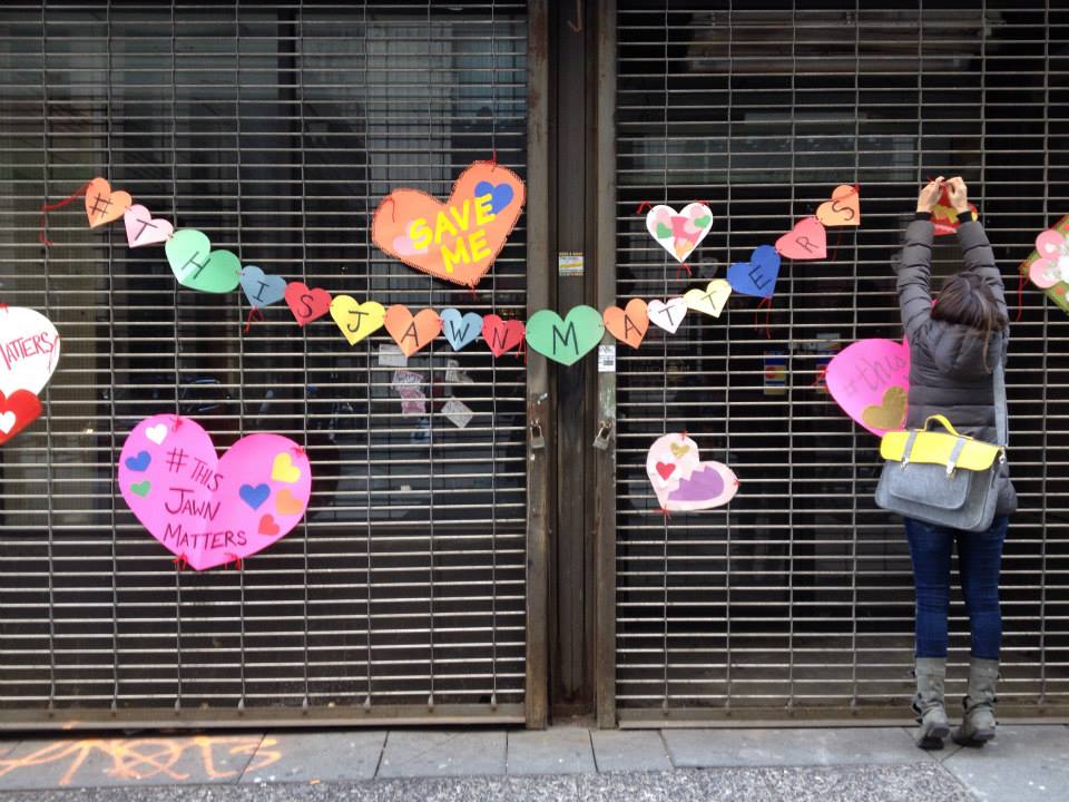 Lynn Alpert hangs a heart on the Hale Building, February 2015. | courtesy of Young Friends of the Preservation Alliance