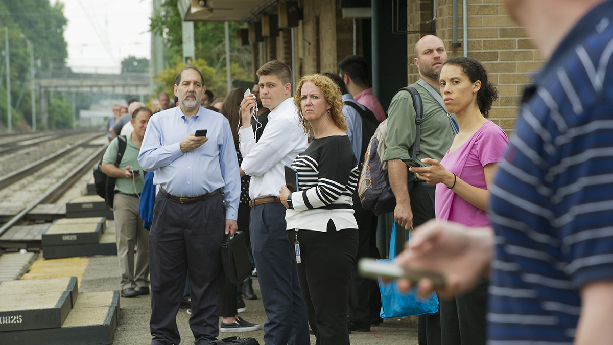 Passengers at the Ardmore Station look up the tracks as a SEPTA train approaches. (Jonathan Wilson for Newsworks)