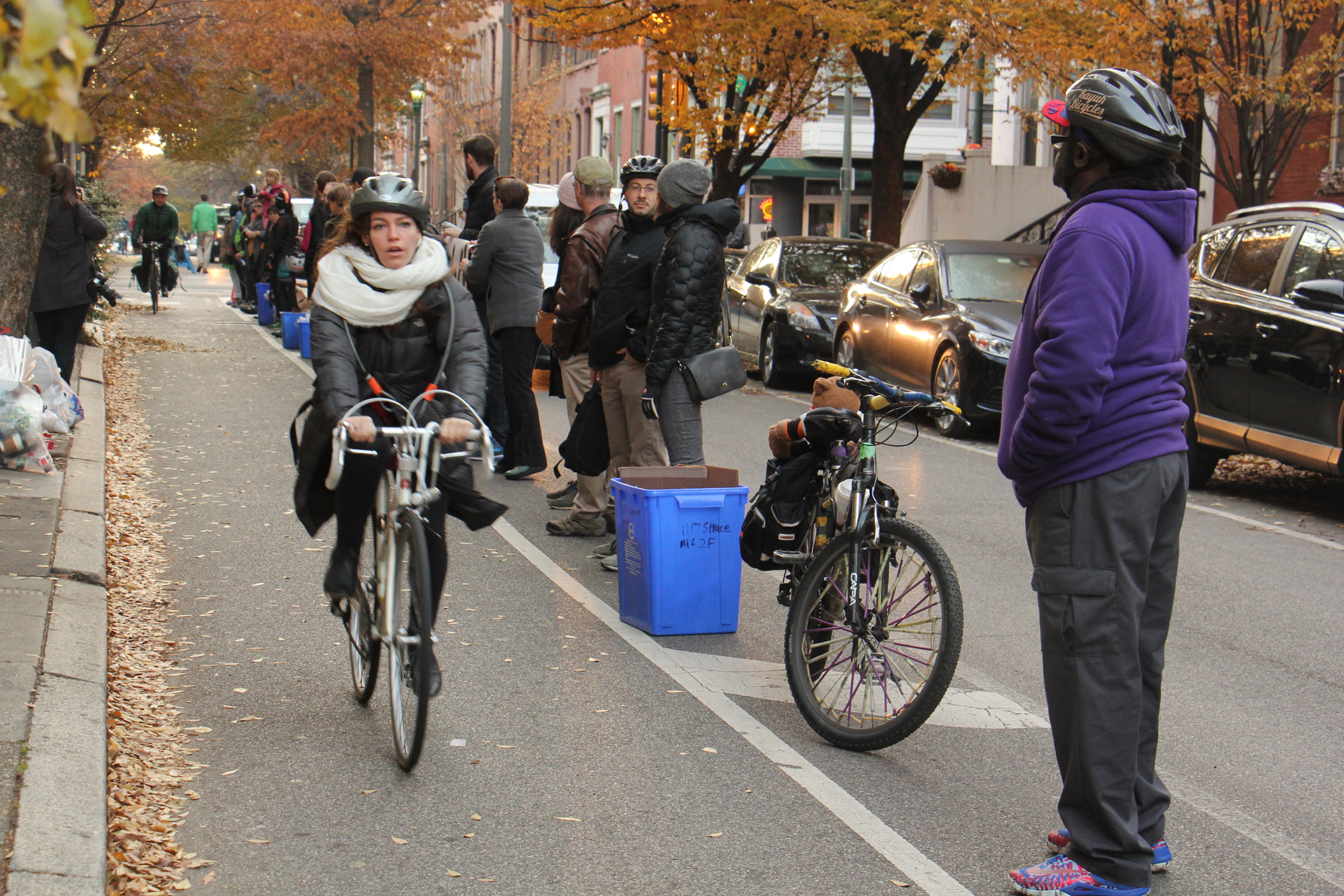 A cyclist bikes down Spruce Street along a human-protected bike lane (Emma Lee, WHYY)