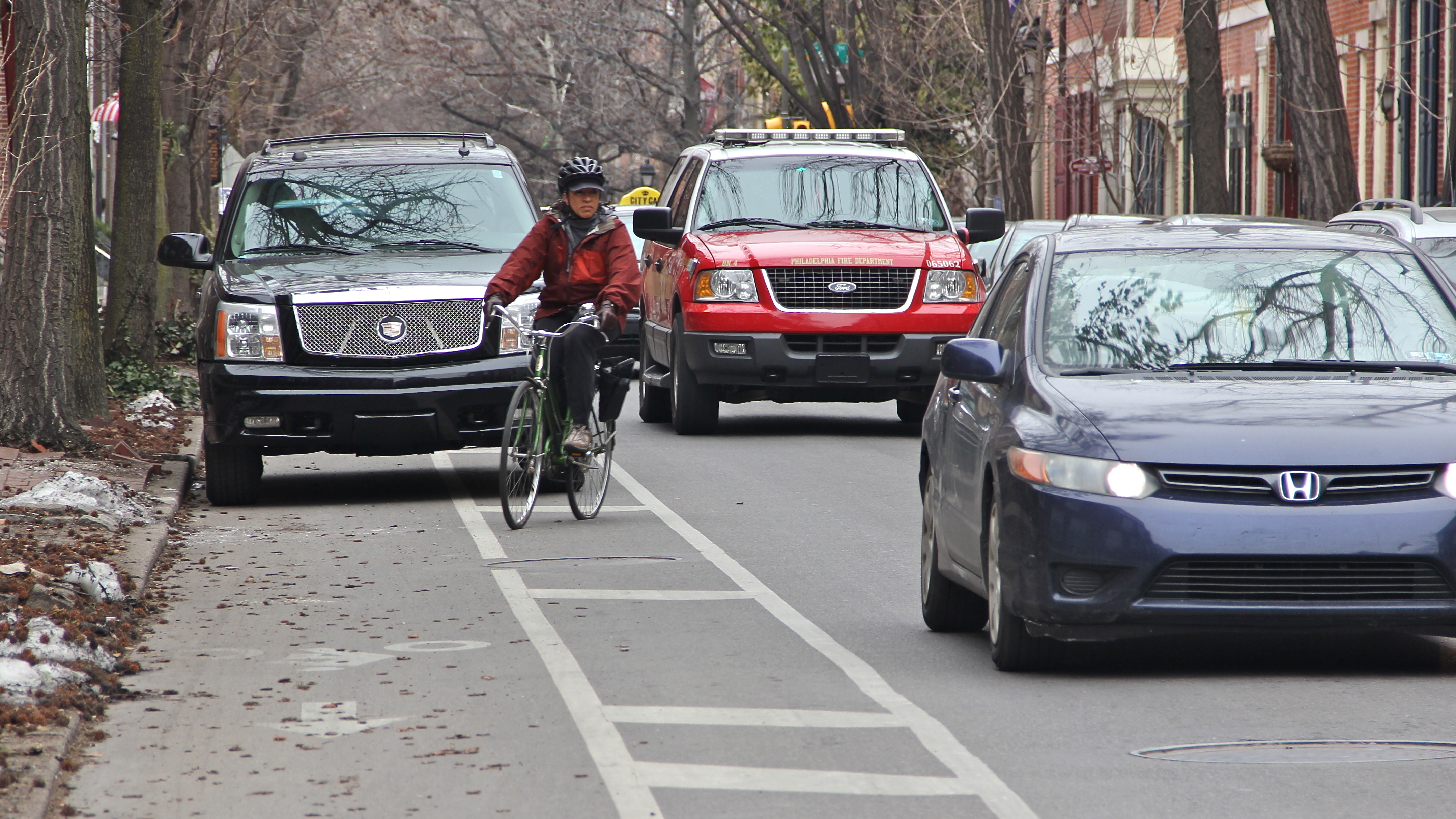 Cars regularly stop in Philadelphia's bike lanes that aren't protected by delineator posts. (Emma Lee/WHYY)