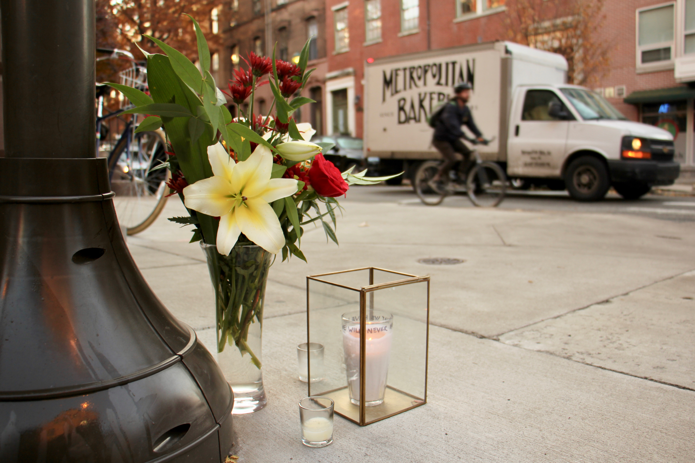 Flowers and candles left at the intersection of Spruce and 11th streets, where cyclist Emily Fredericks was struck and killed (Emma Lee, WHYY)