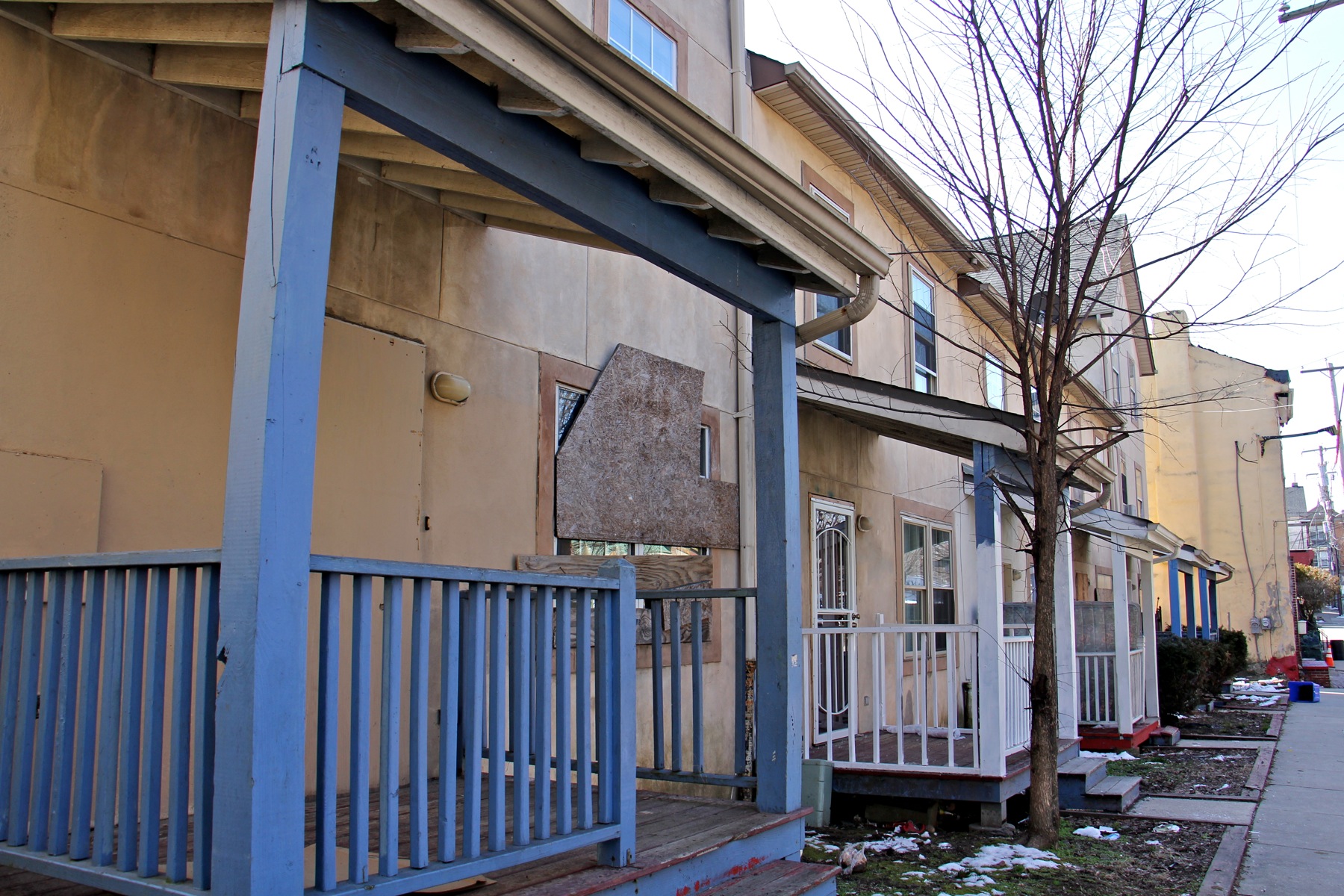 Homes in the unit block of Wister Street, some still occupied, show signs neglect. (Emma Lee/WHYY)
