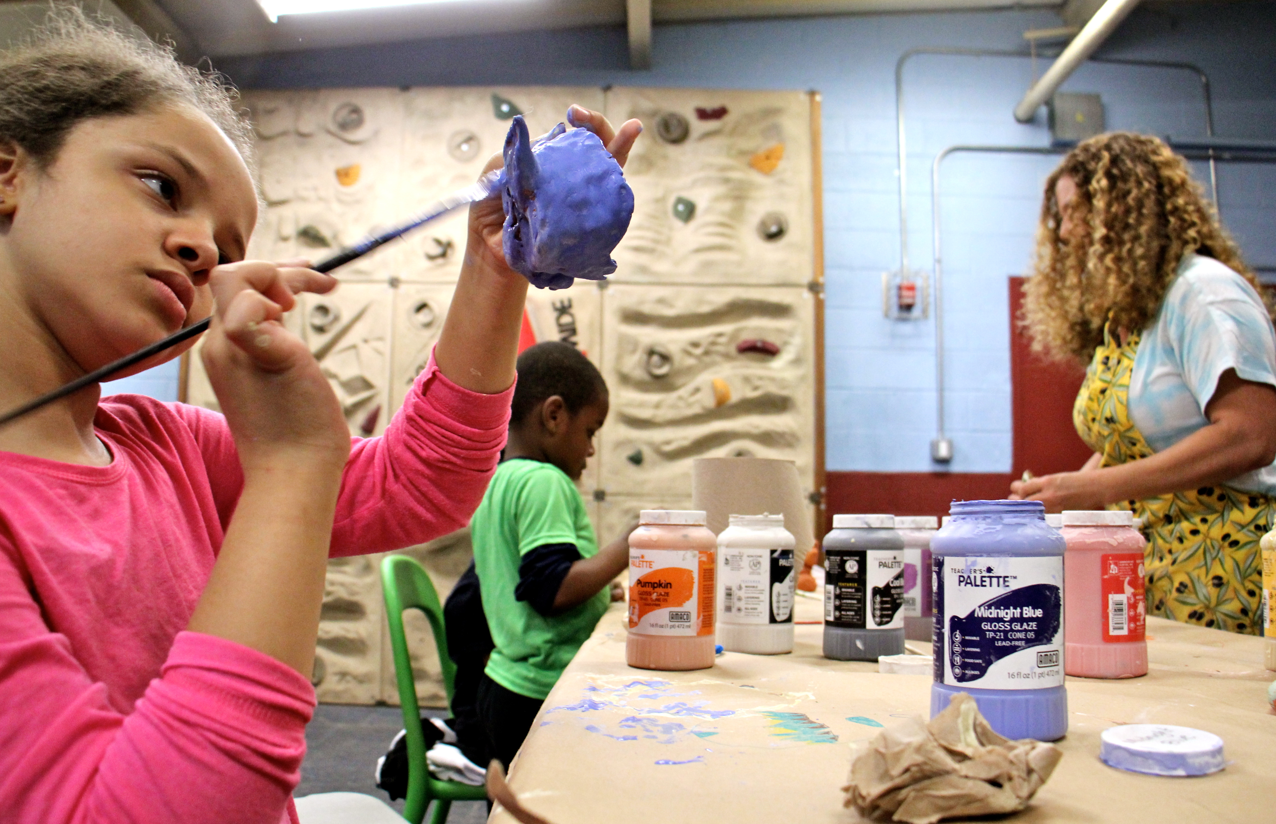 Isabel Slaughter, 8, paints a ceramic sculpture in Emily Coleman's ceramics class at Olney Rec Center. (Emma Lee/WHYY)