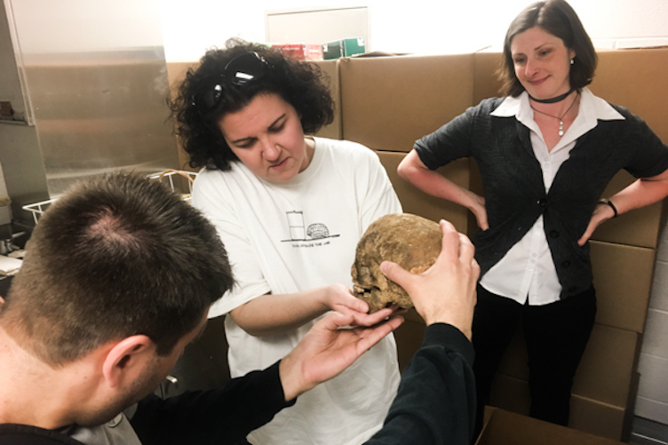 Jared Beatrice (L), Dhody (center), and Kimberlee Moran meet at Moran's lab at Rutgers-Camden to review some of what was excavated from 218 Arch Street in Philadelphia last month. (Elana Gordon/WHYY)