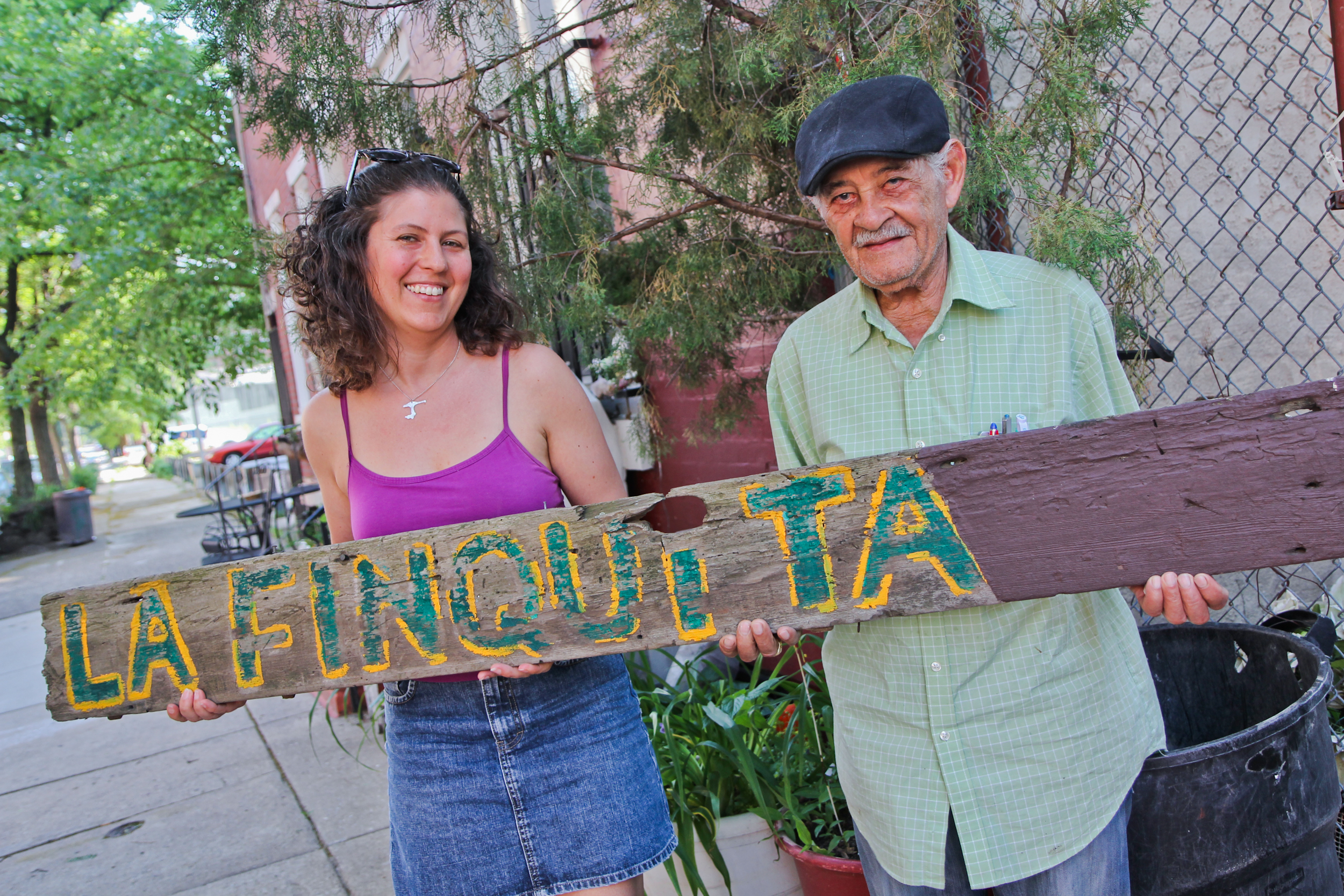 Jessica Noon and Daniel Rodriguez holds the hand-painted sign that remains from the now-departed La Finquita at Lawrence and Master streets. 