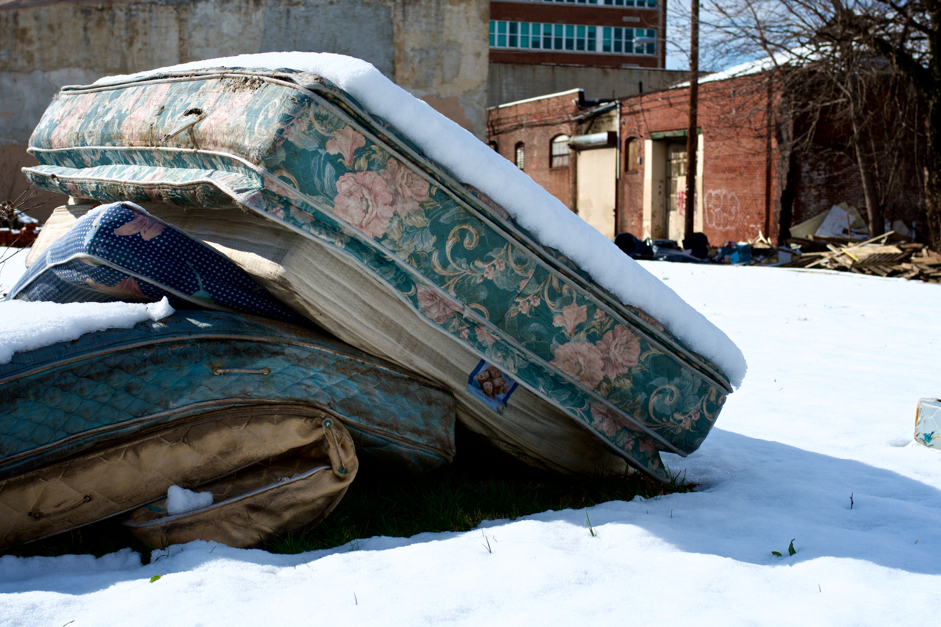 Mattresses piled up in a vacant lot. (Bas Slabbers/WHYY)
