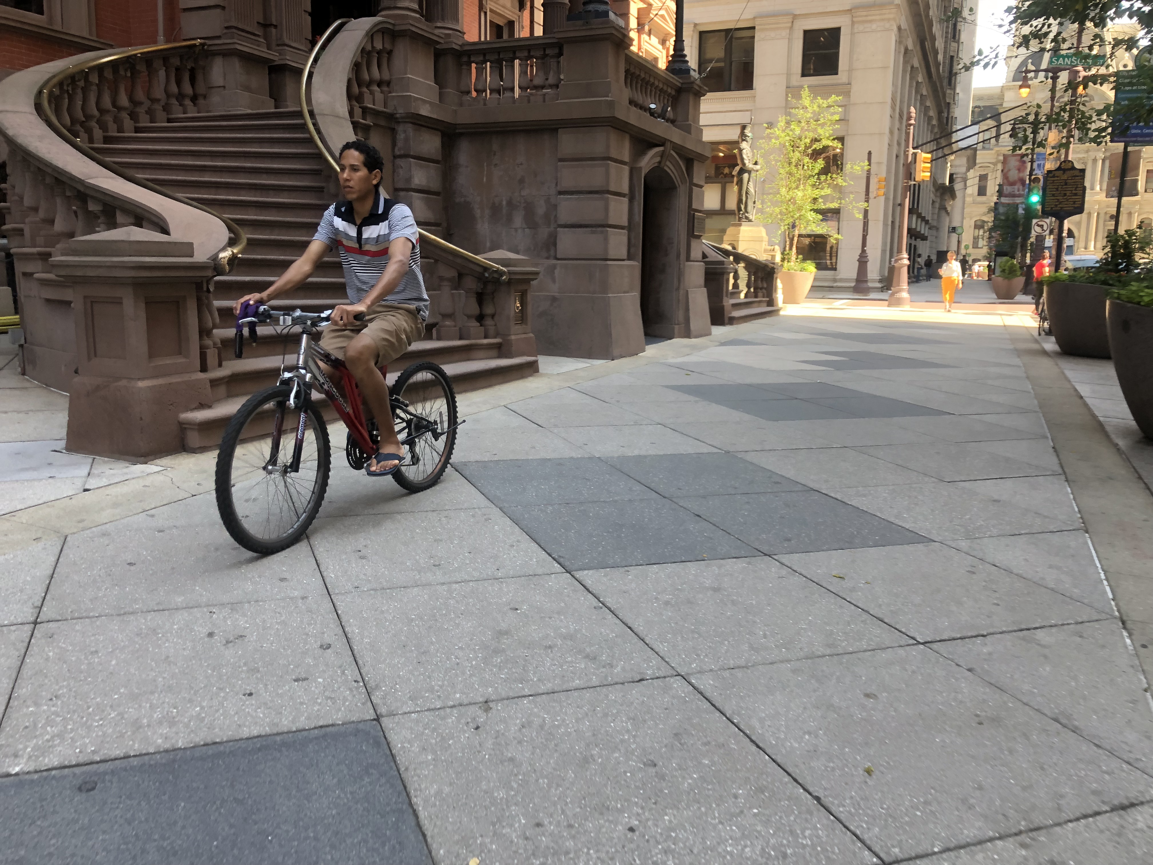 A cyclist rides along the sidewalk in front of the Union League on South Broad Street | Meir Rinde
