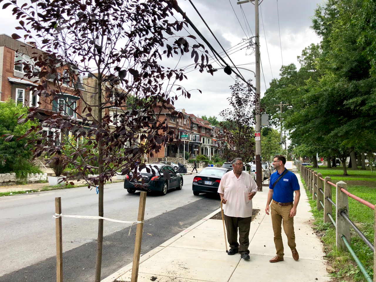 Gregorio Pac Cojulun (left), and Dan Schupsky, an outreach specialist, stroll along one of the new sidewalks.