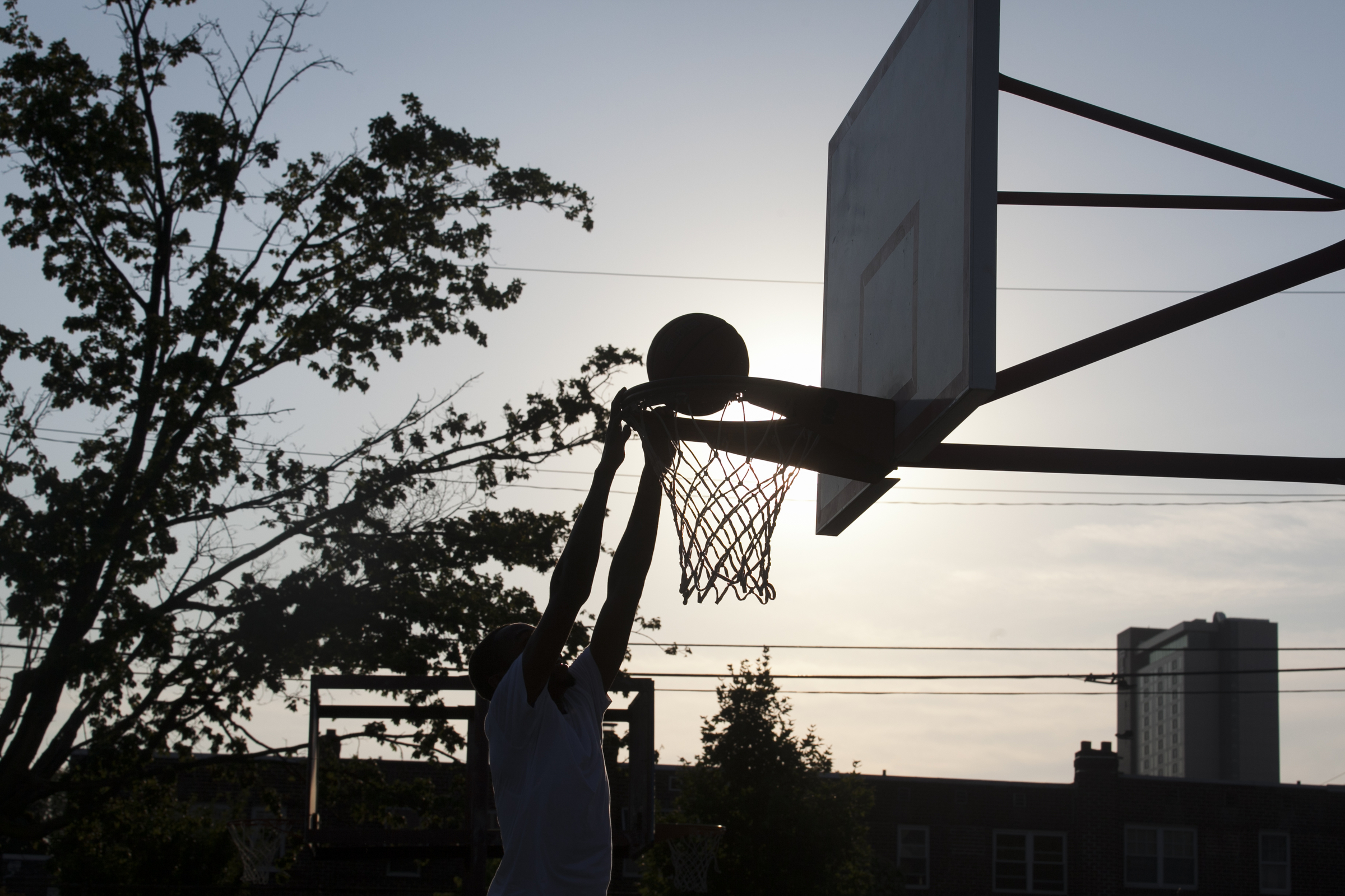 Keith Bolden dunks a basketball as the sun sets at Dendy Playground on July 10. | Maggie Loesch       