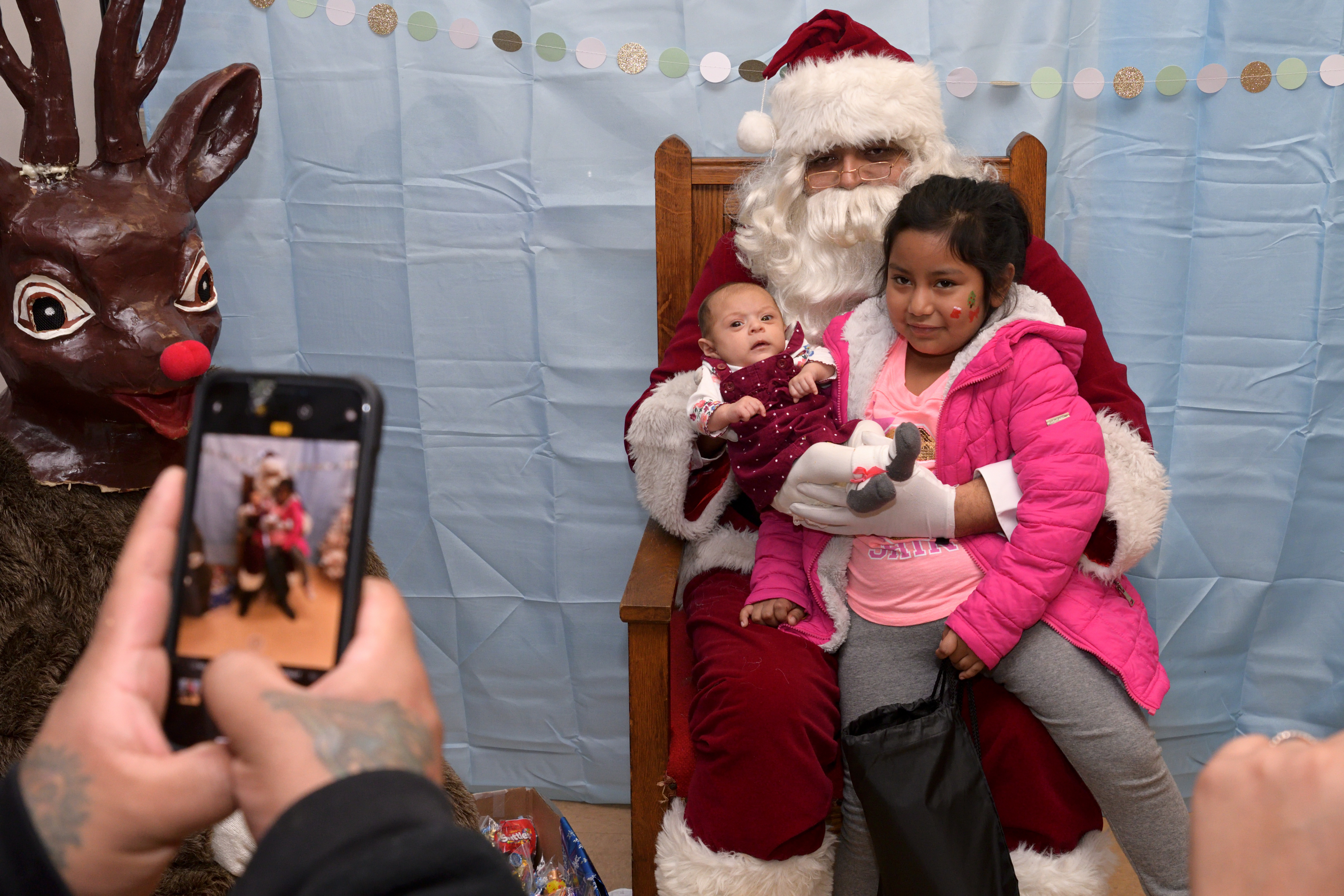Kids pose for a picture with Santa and Rudolph at the Annual Winter Festival in Olney. Bas Slabbers/WHYY.