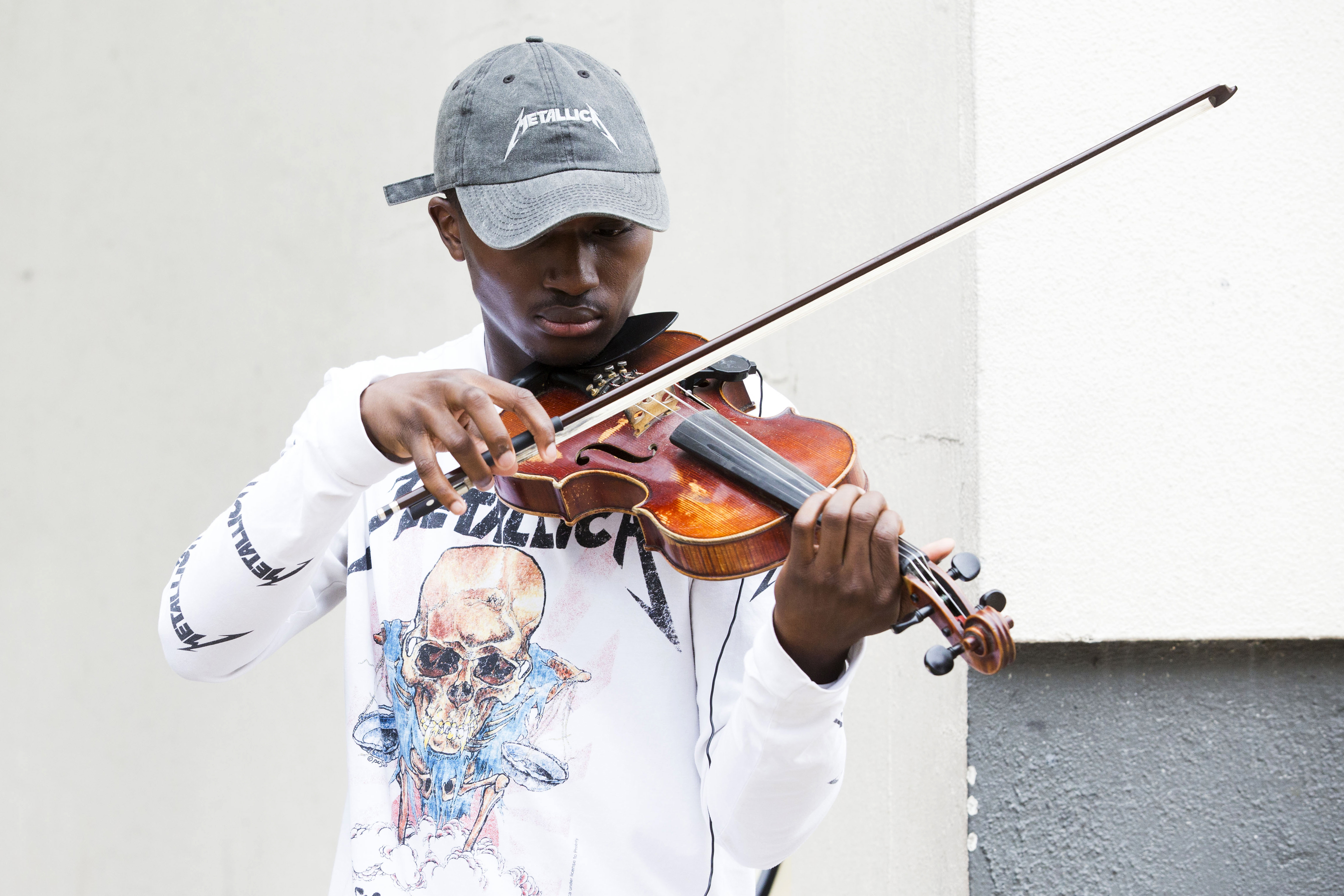 Rickey Turner, 21, plays the violin outside the Made in America festival.