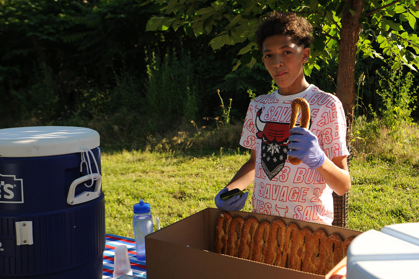 Tacony Creek Park Keeper James Megron passes out pretzels and water during the Tacony Creek block party. 