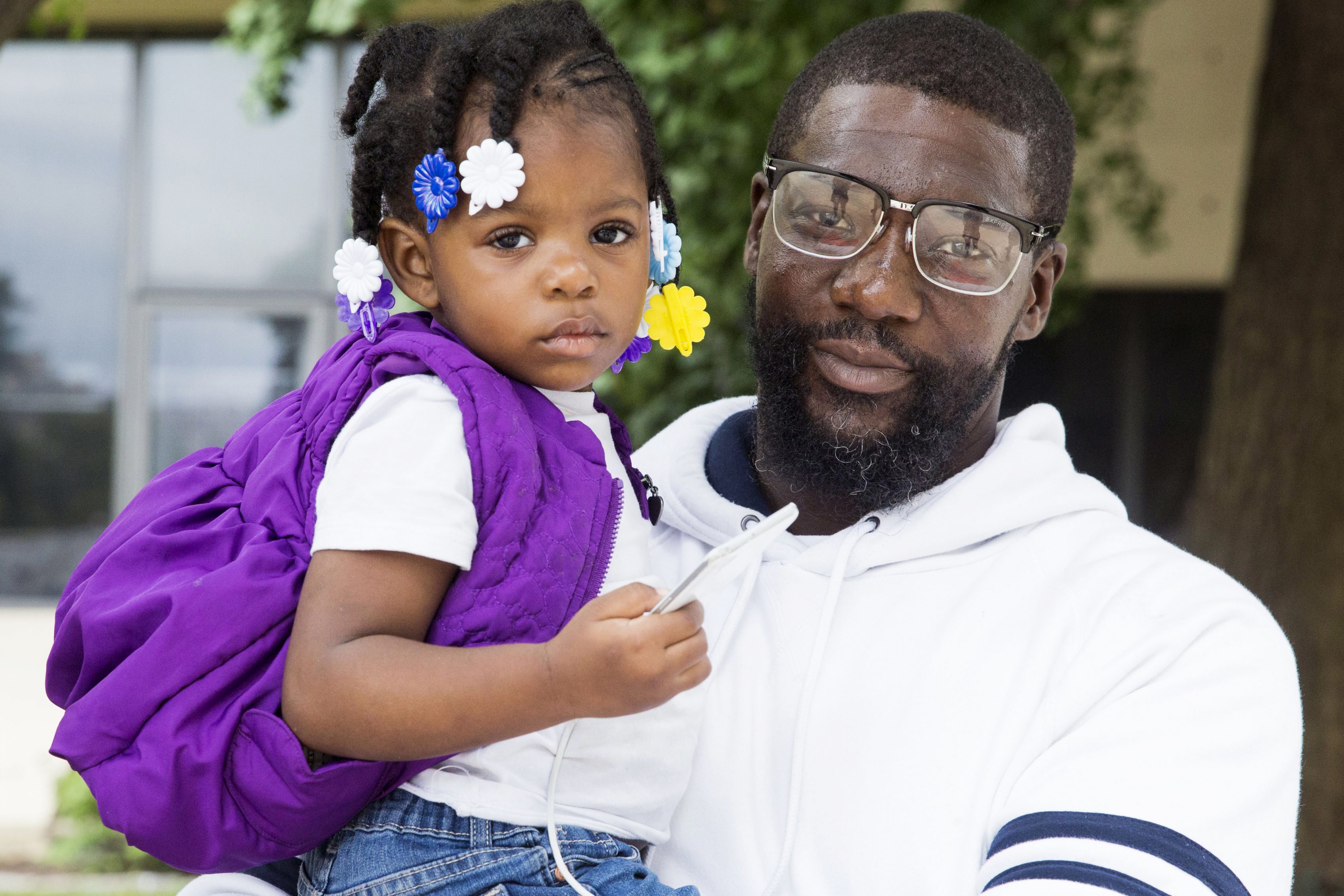 Warren Kale, 42, holds his daughter, Katie, 2 outside the Made in America Festival. (Rachel Wisniewski for WHYY)
