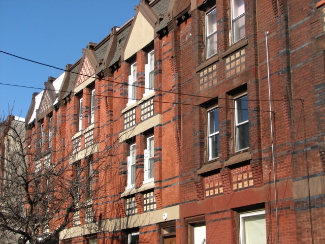 A row of 19th century houses at 1821-1833 Thompson St. is distinguished by the elaborate brickwork and terra cotta insets.