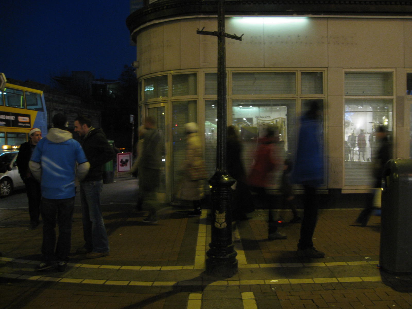 Locals passing a closed storefront while doing their Christmas shopping on Grafton Street