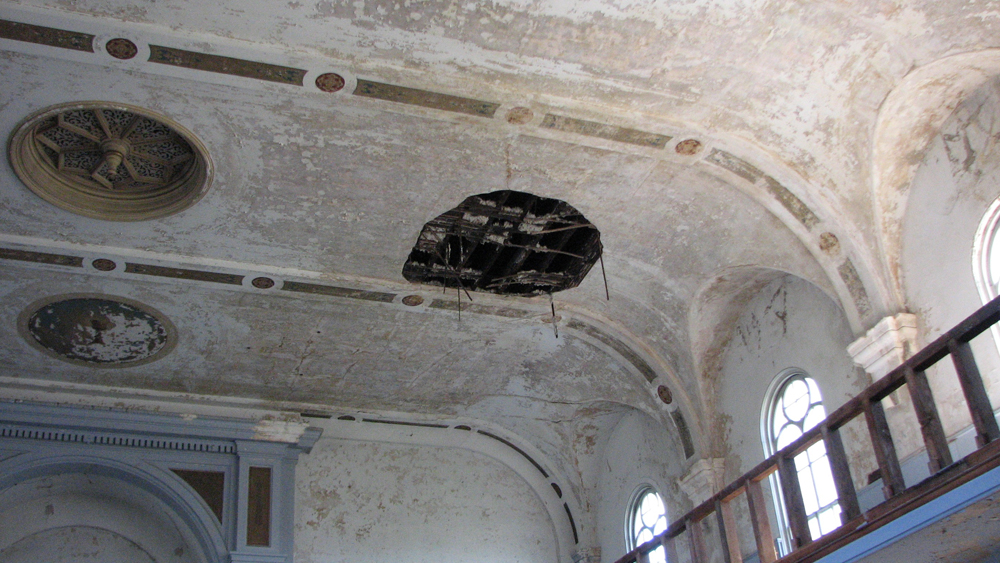 Holes scar the once-ornate ceiling.