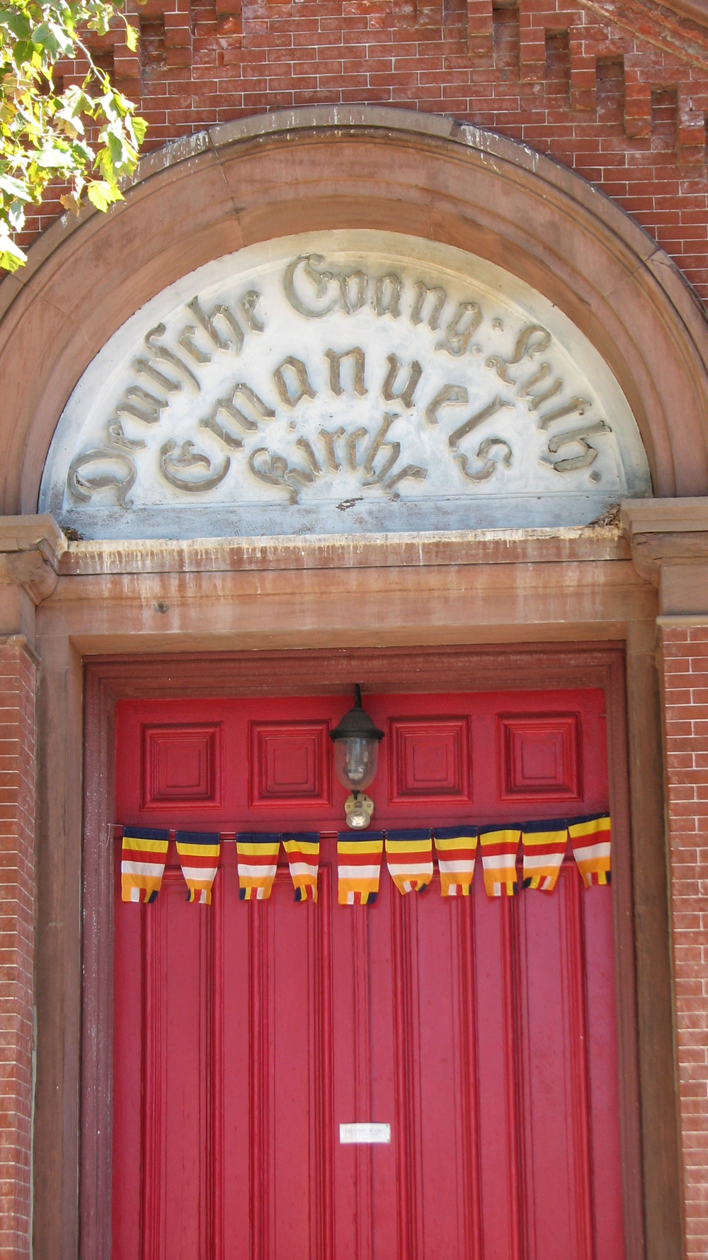Flags of the new congregation now hang below the original German inscription on the building entrance.