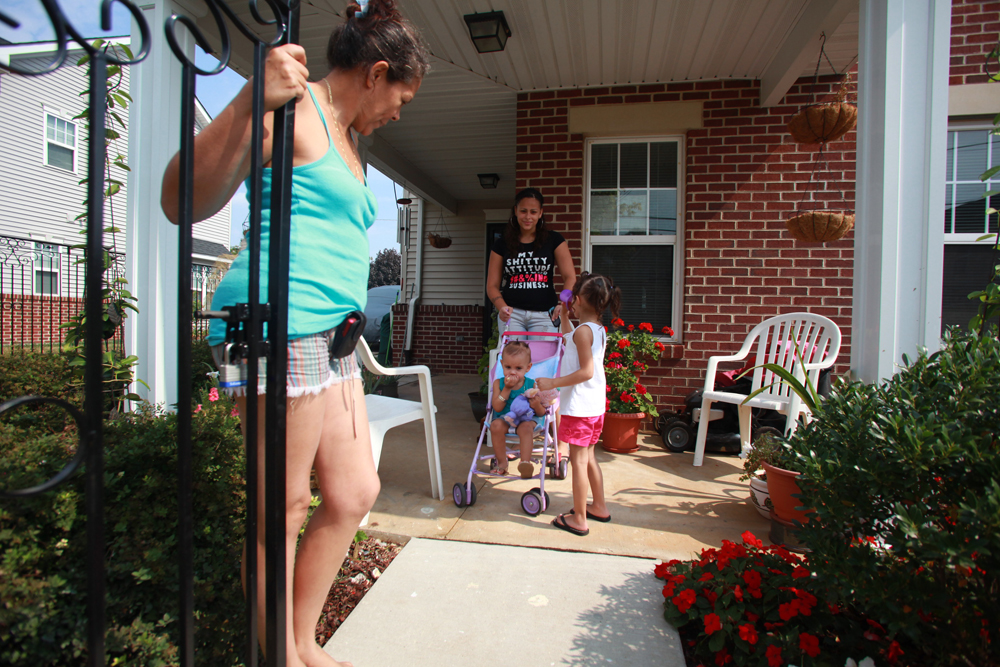 Michelle Laguna (center) prepares to leave her home located near 6th and Norris streets while taking her kids for a walk.