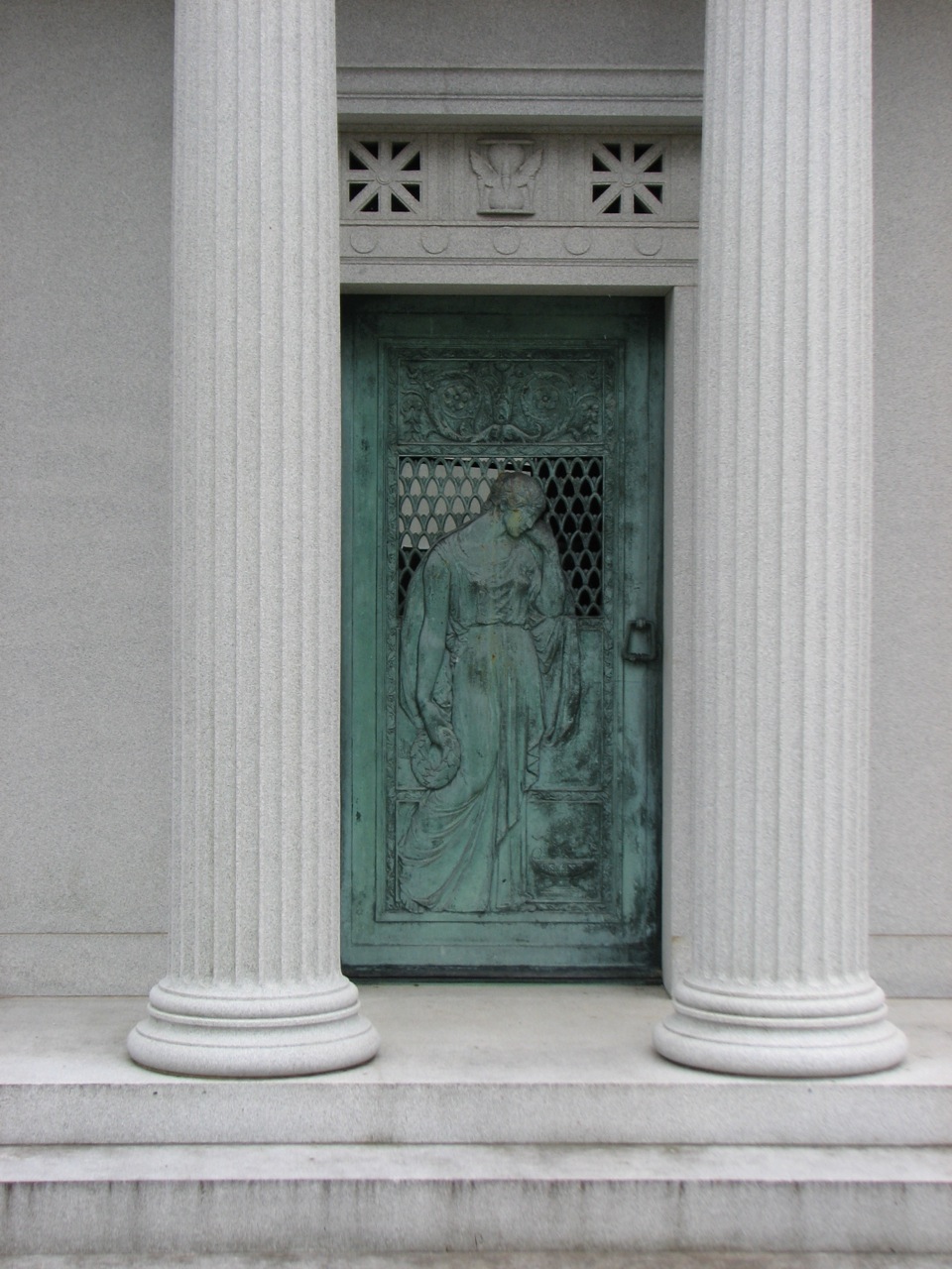 Classical columns and the figure of a woman adorn the entrance to a turn-of-the-century mausoleum.