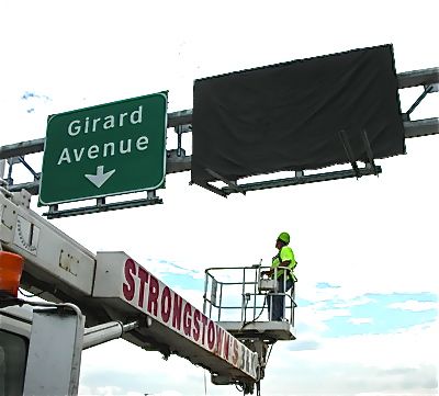 PennDOT worker installing the new Girard Ave signs. (PennDOT photo)