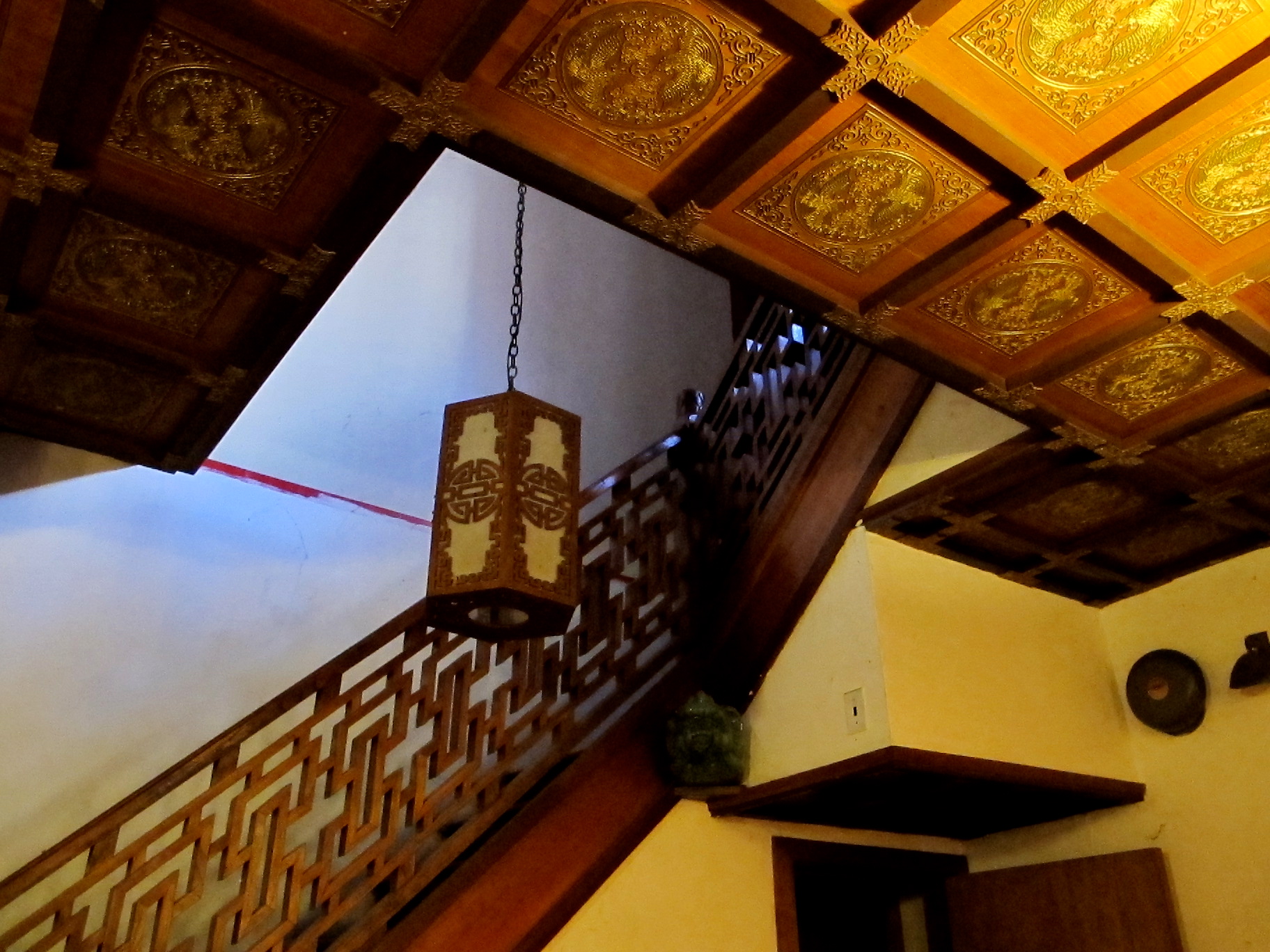 A painted, coffered ceiling and carved wooden railing are among the traditional elements of the stairhall.