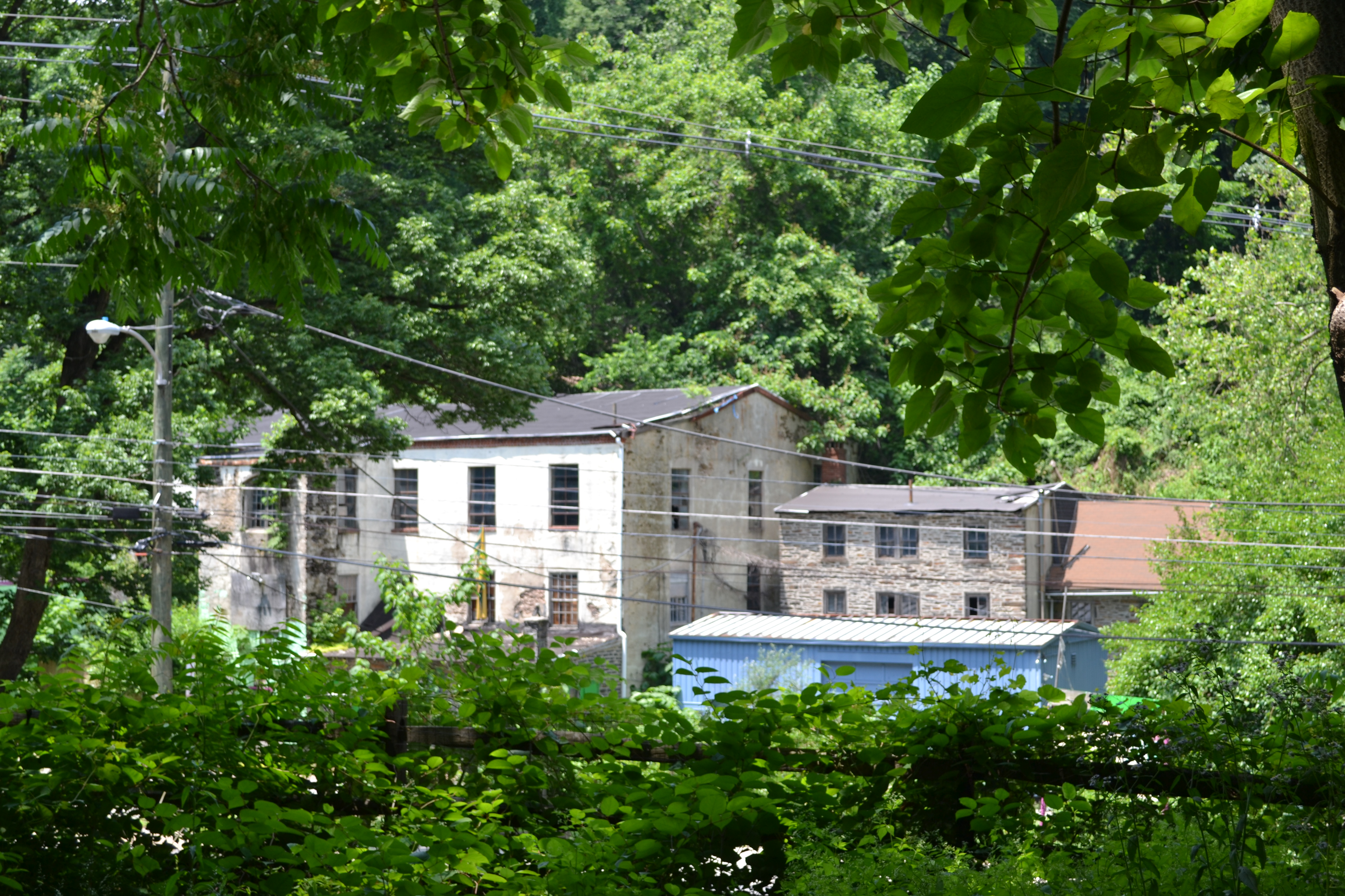An abandoned mill building stands across from the Rock Hill Road and Belmont Ave end of the trail