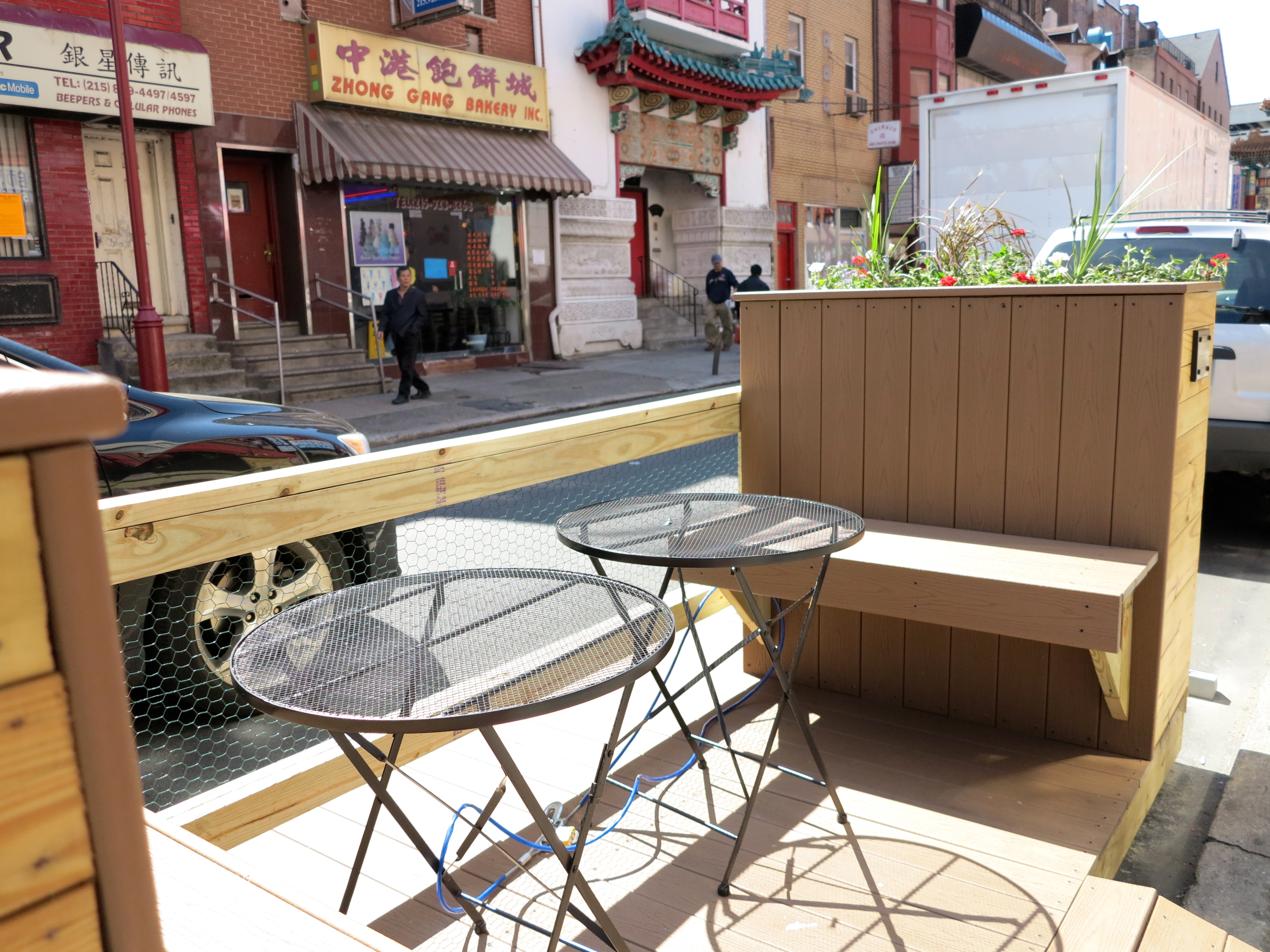 The parklet features built-in benches and two tables.