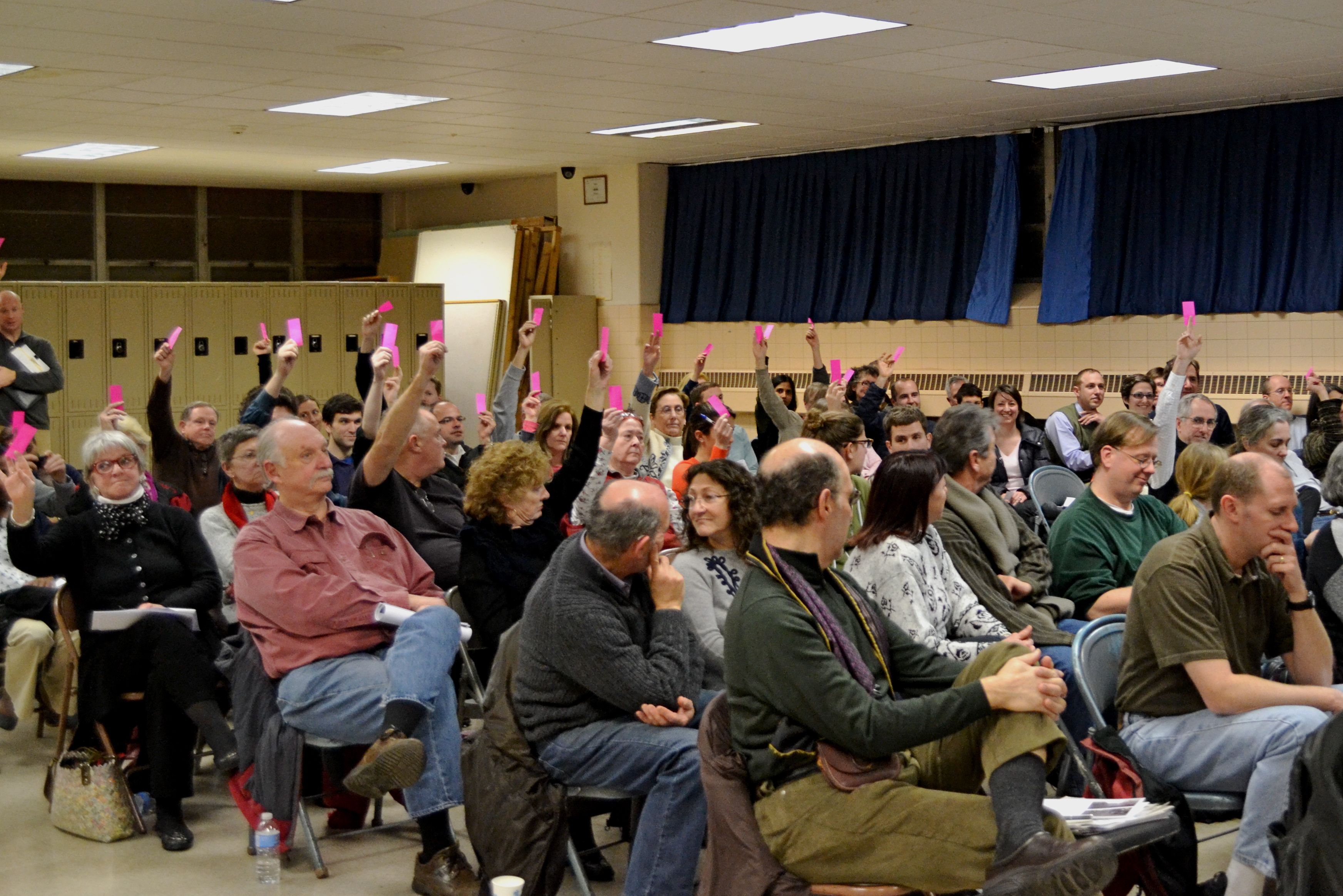 Members showed support for the proposed Fairmount Bike Lanes by raising their pink voting cards