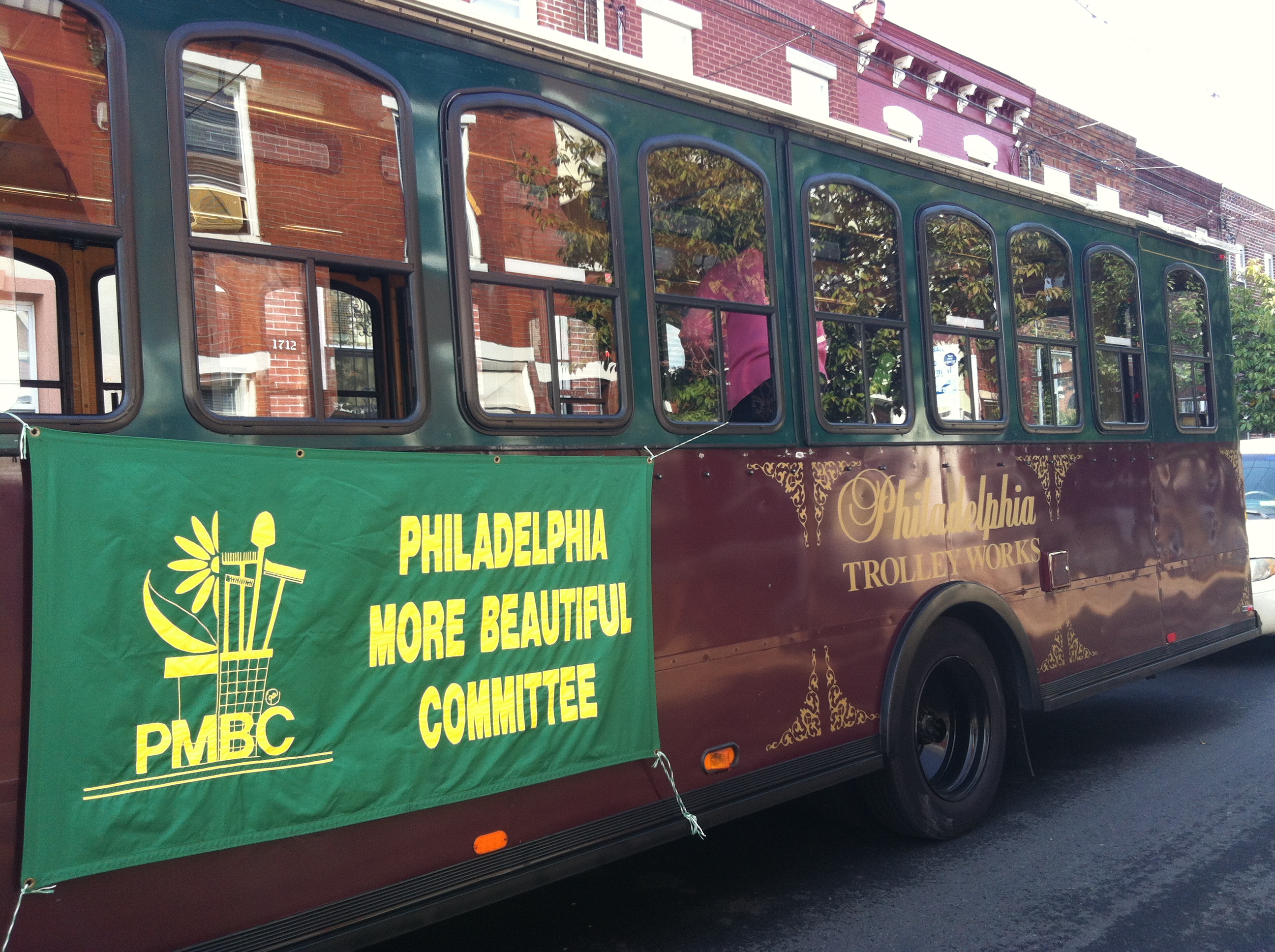 Around 20 citizen judges ride on the Philadelphia More Beautiful Clean Block Contest trolley escorted by police and several city vehicles.
