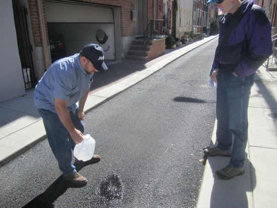 PWD's Pete Reilly demonstrated how water poured directly onto the porous paving on Percy Street seeps into the ground, rather than puddling