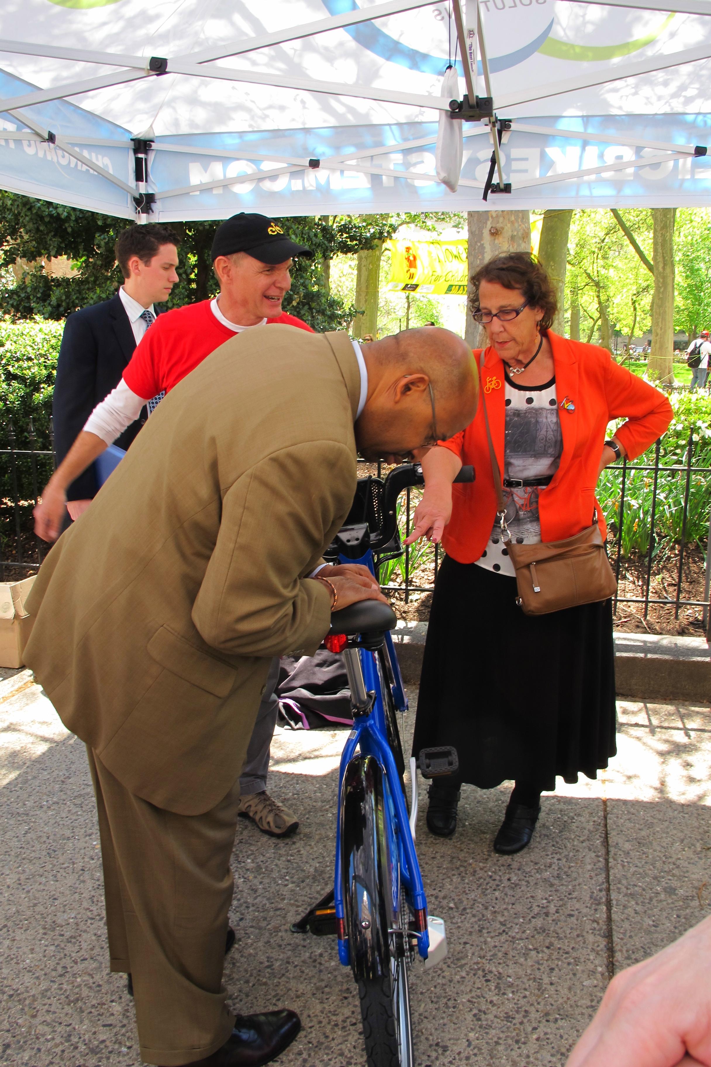 Mayor Michael Nutter, Deputy Mayor Rina Cutler kick the tires as Alta's Charlie Denney explains their system and bikes. 