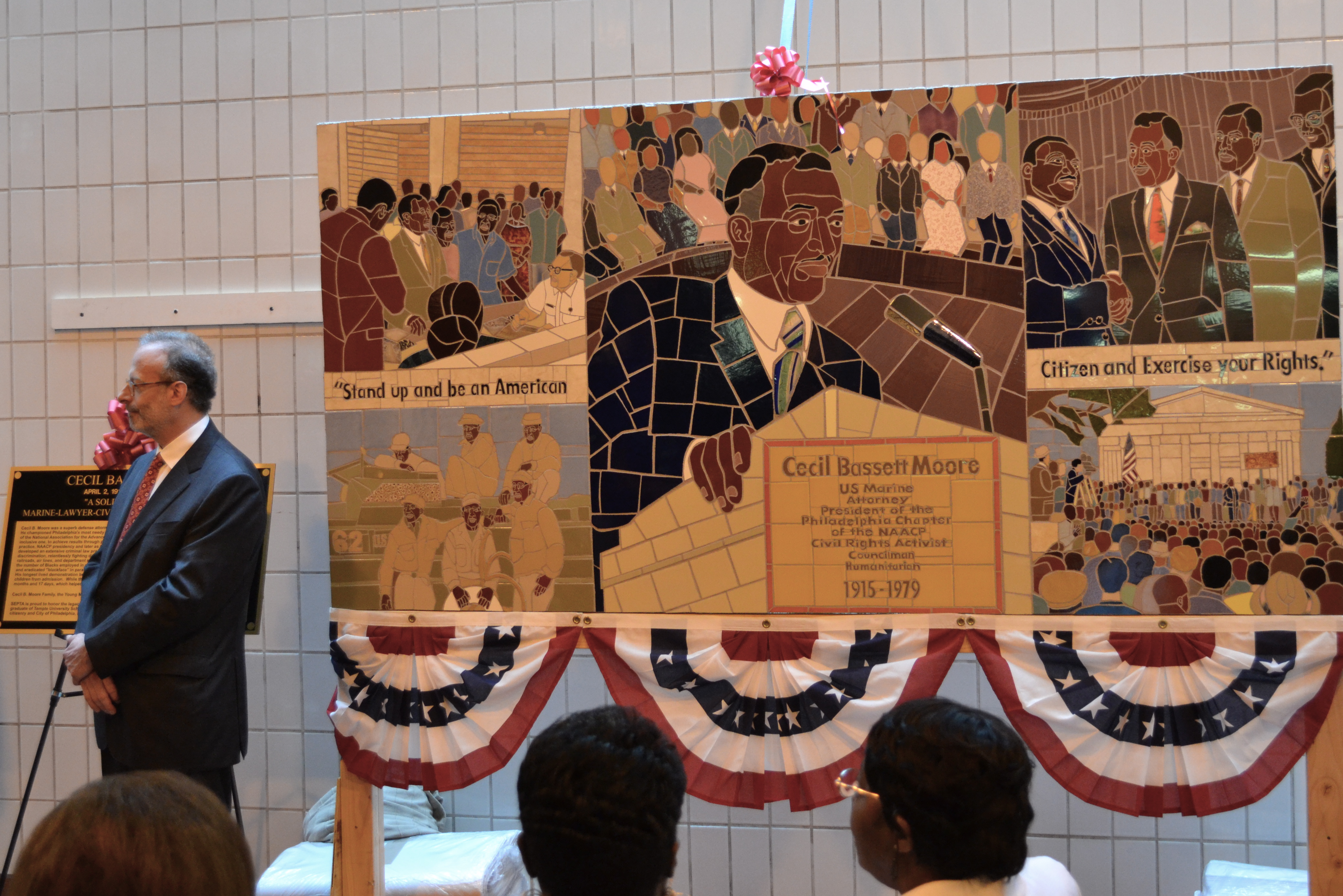 Local artist Jonathan Mandell stood next to the mural he created during the ceremony