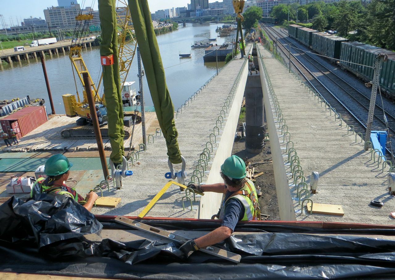 Crews guide one of the ramp's beams into place