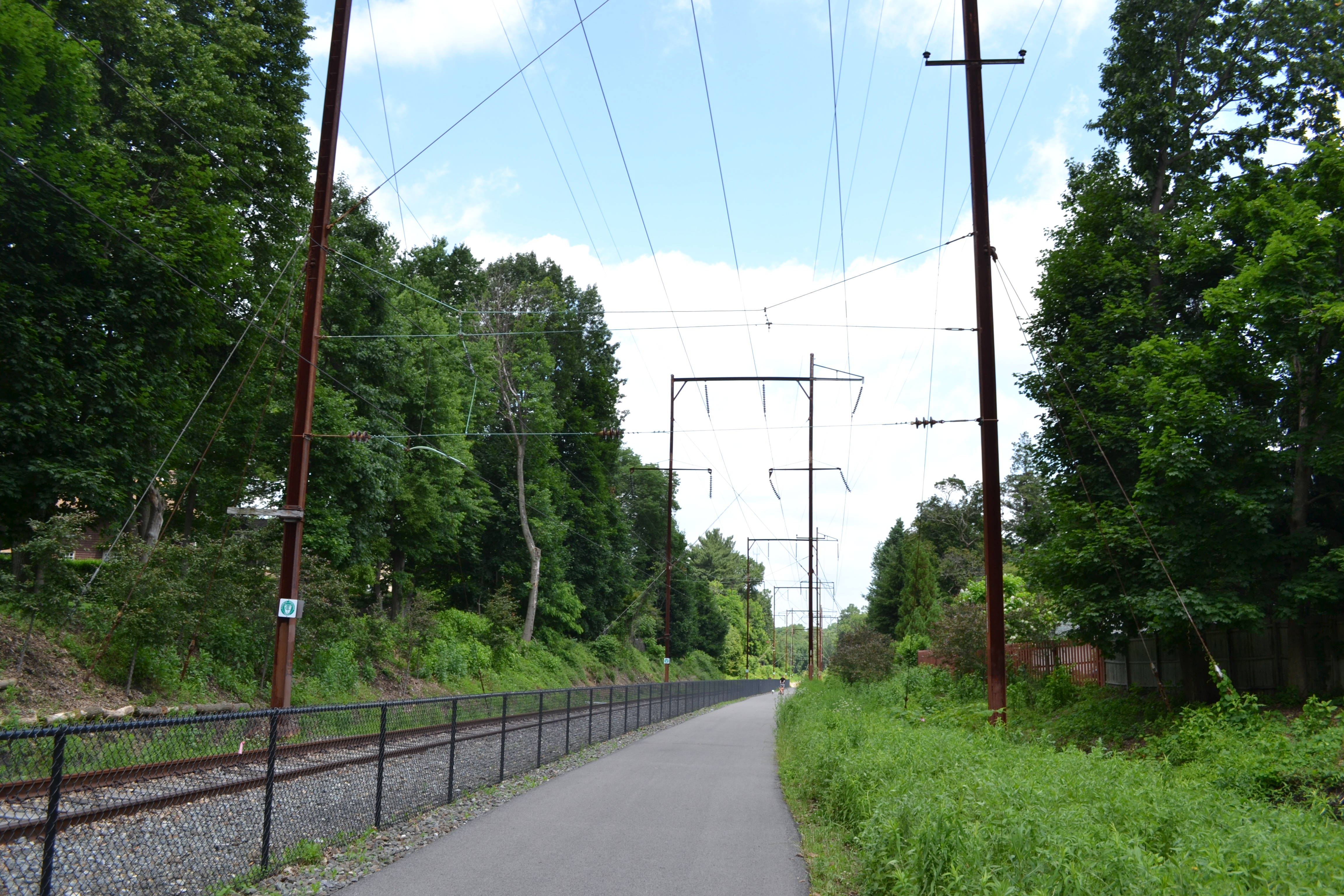 The paved portion of the trail starts alongside an existing segment of tracks