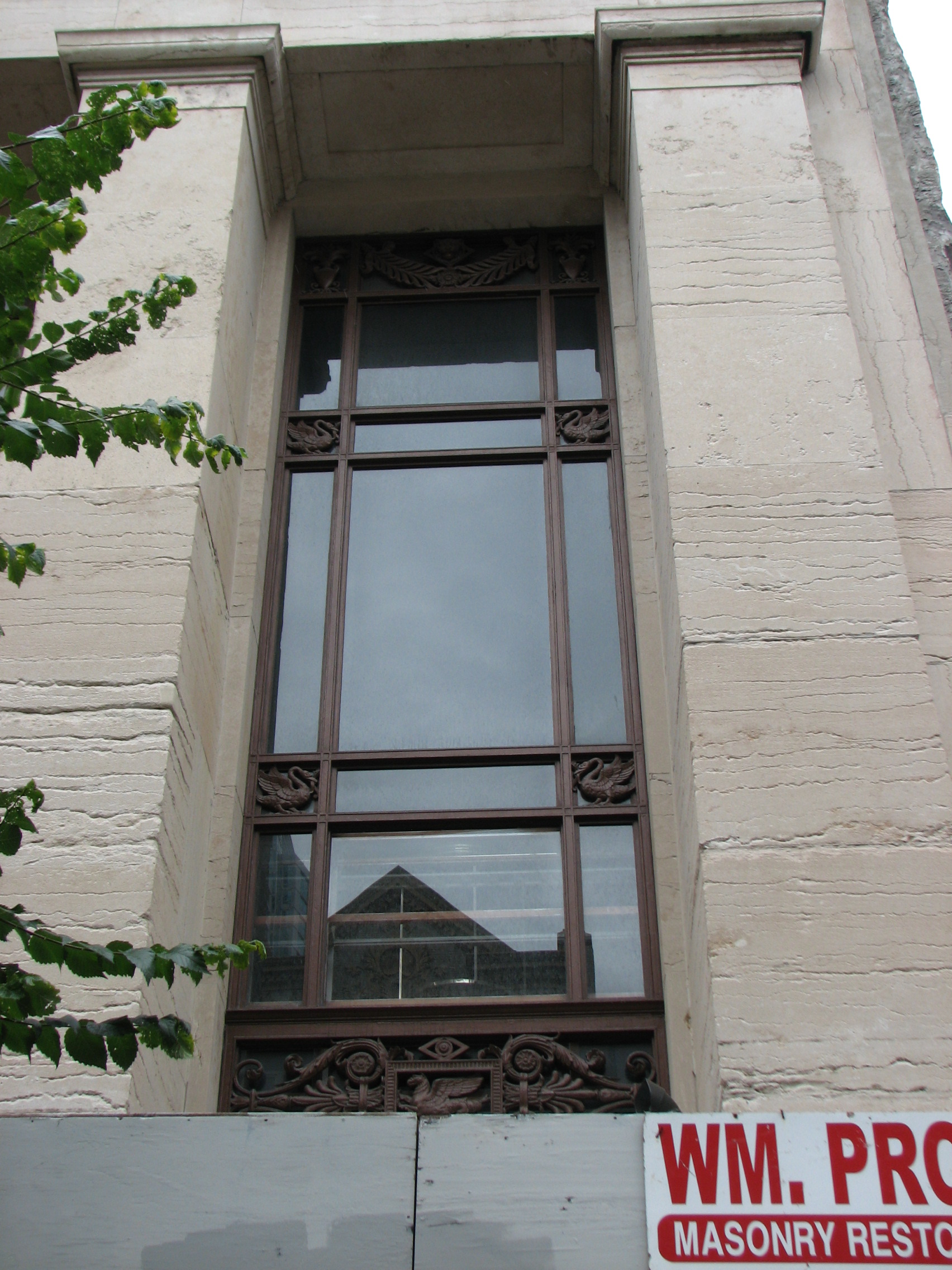 The building’s vertical columns are broken by deep-set windows with decorative frames.