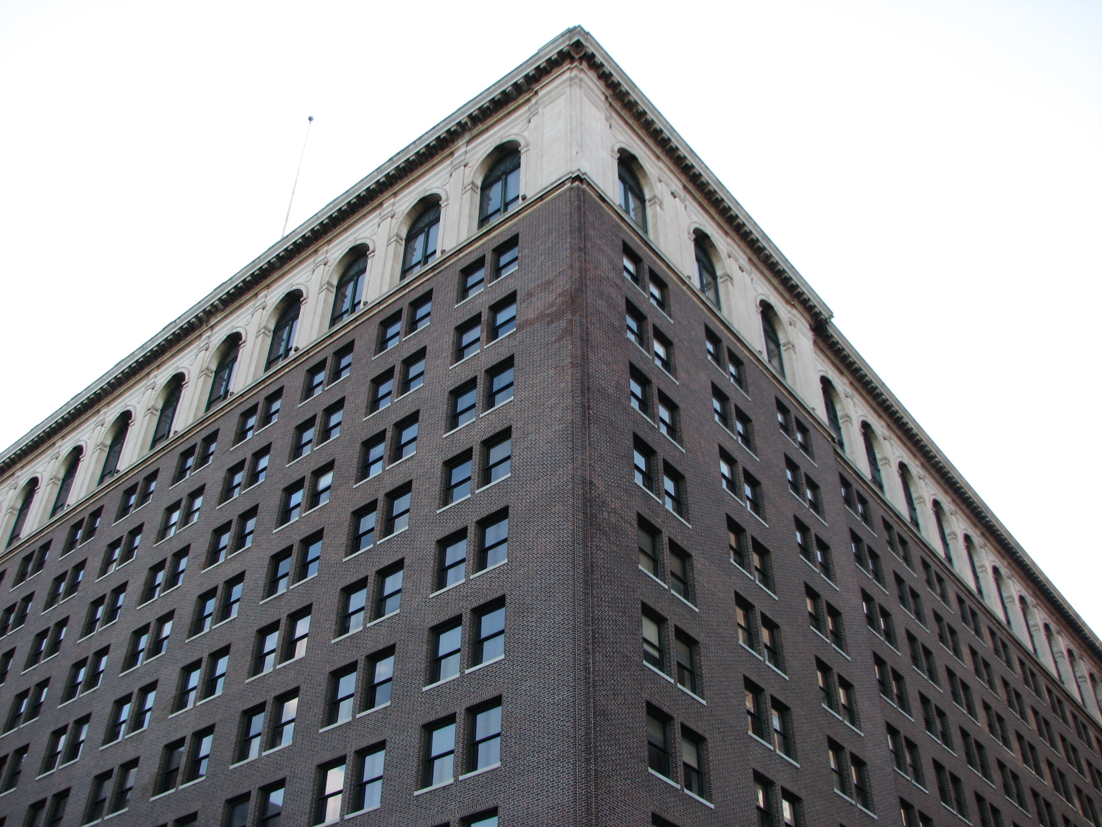 The brick midsection of the building reflects its utilitarian role, but Trumbauer topped the building with a row of white marble arches.