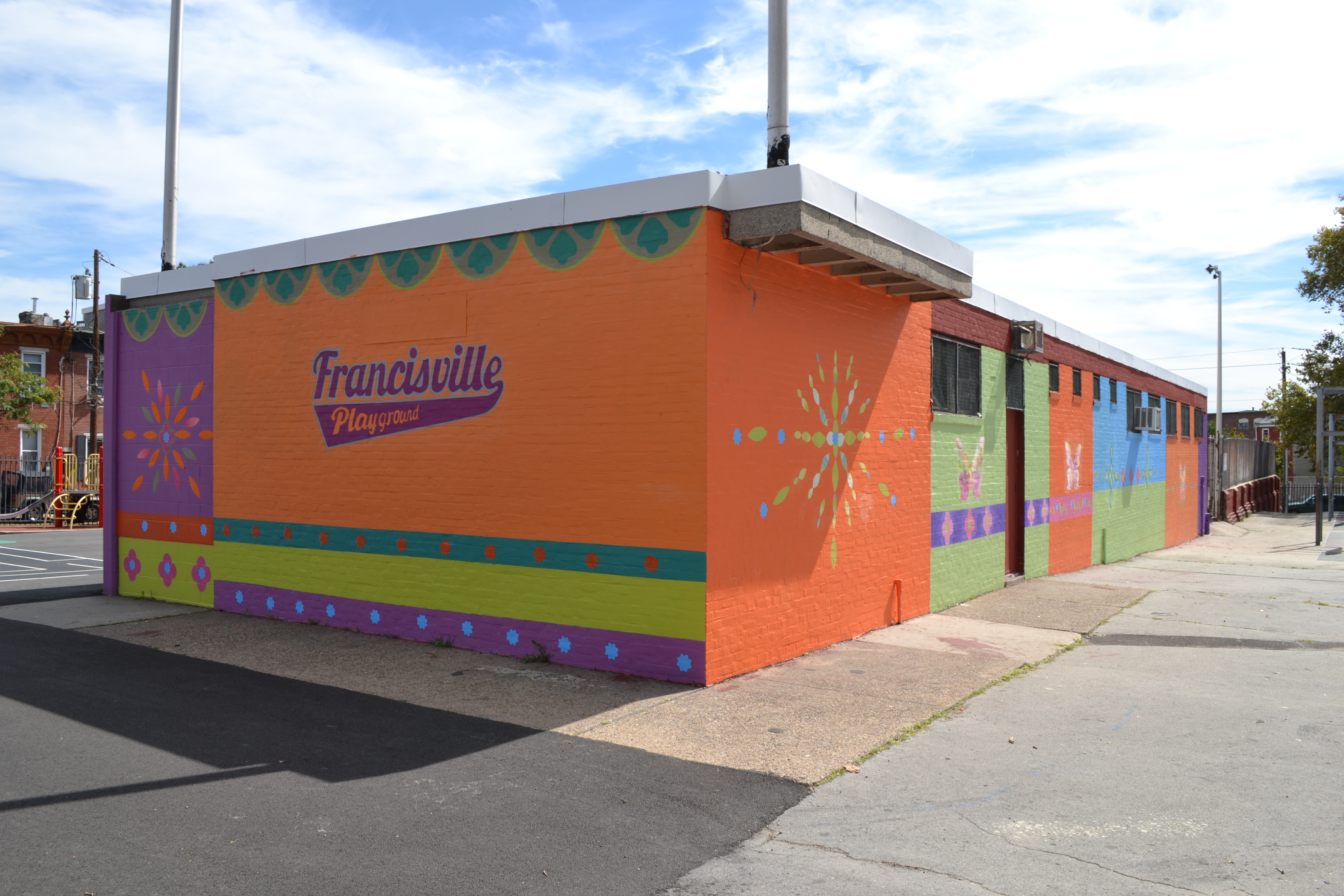 Mural Arts painted a bright mural on the rec center next to the revamped playground