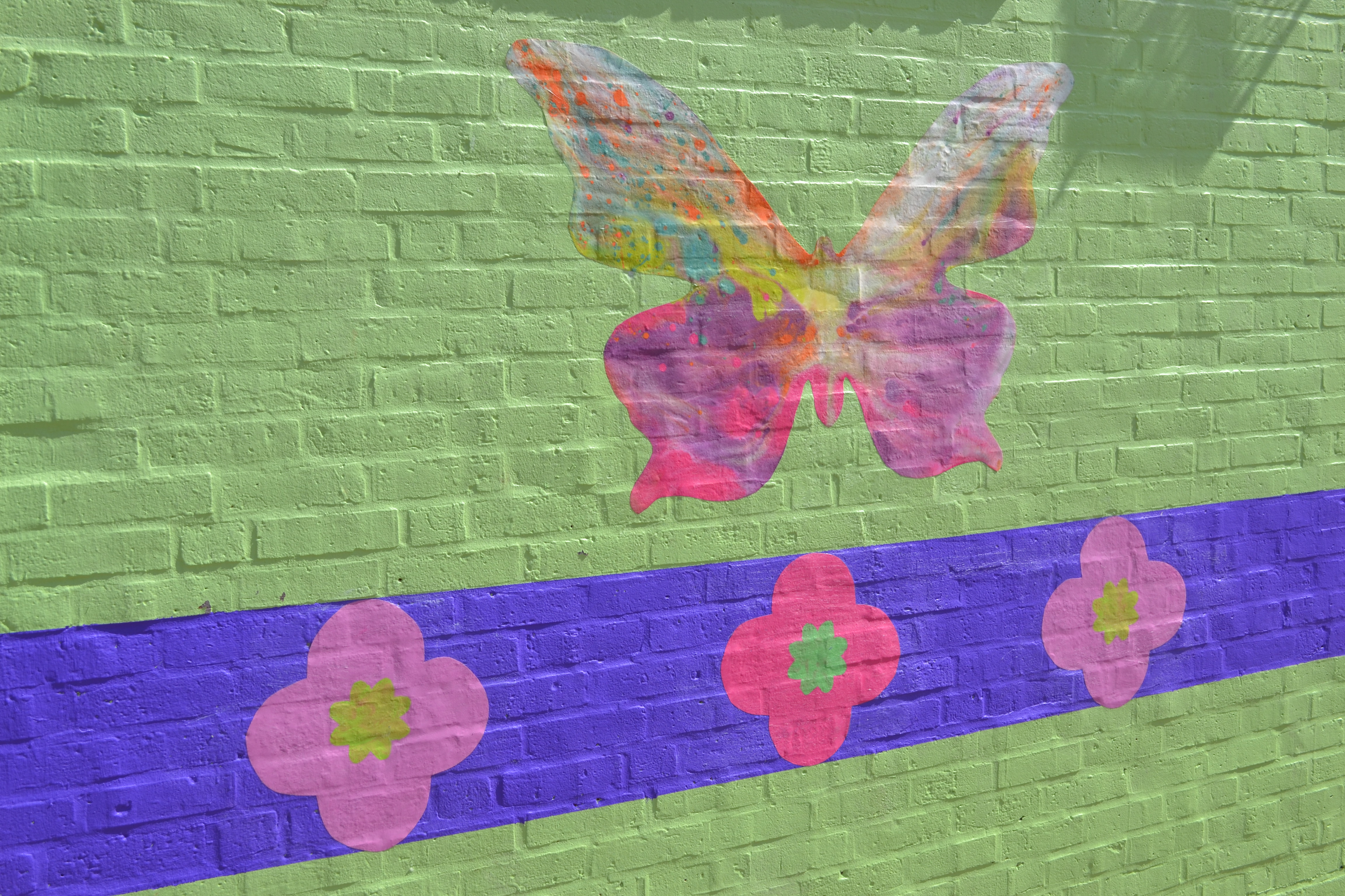 Pre-K students and some summer camp attendees helped paint butterflies on the mural