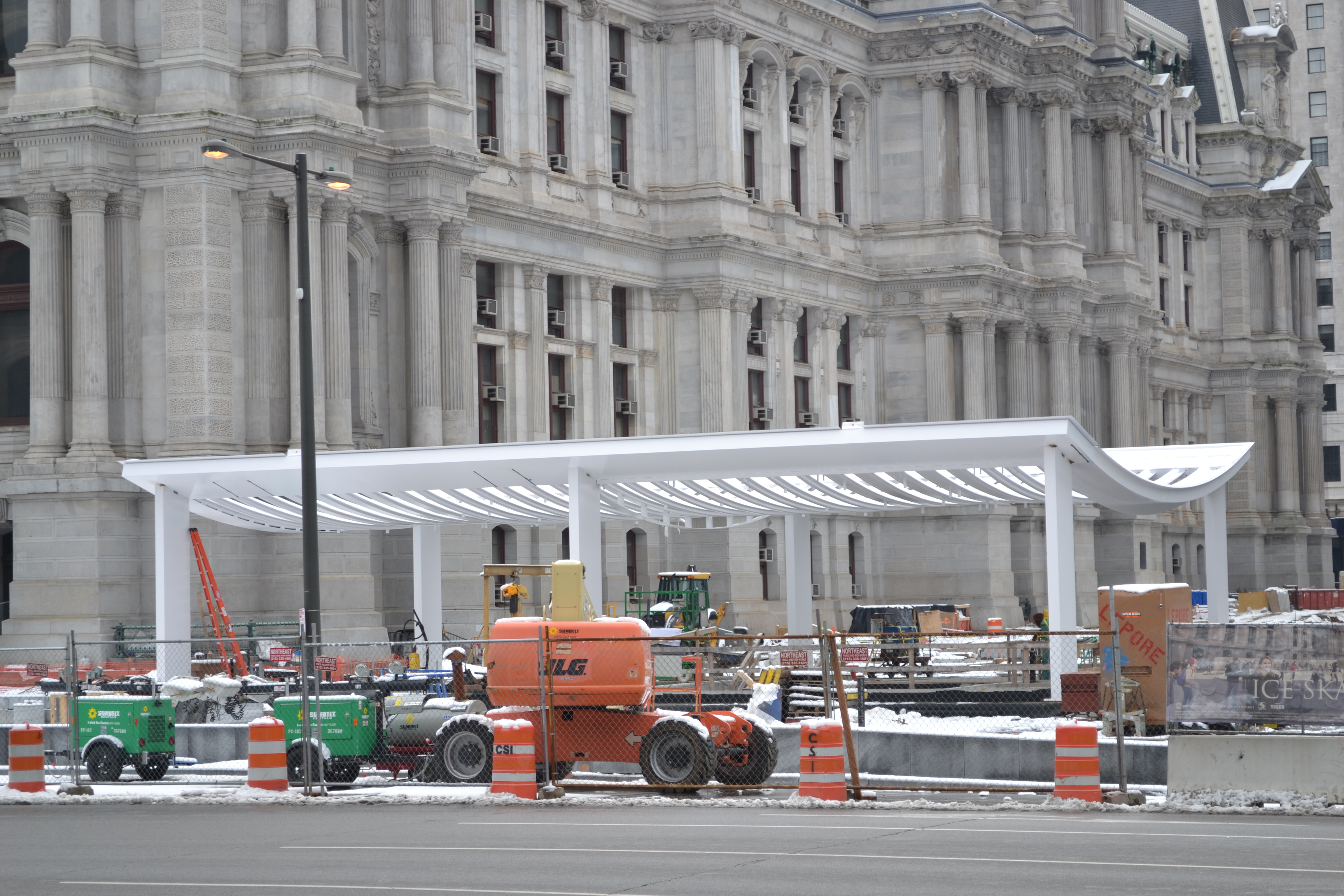 The white frame stands out against the gray backdrop of City Hall and the construction site