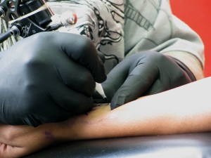 Eric Doyle of Mark My Flesh tattoo shop on Frankford Avenue perfects a tattoo, which reads Kendrell with a heart, on Jasmine White's wrist. 