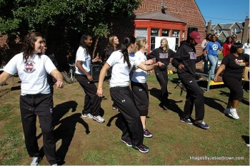 Temple University's Women's volleyball team demonstrates gospel line dancing to Castor Gardens residents looking to get fit.