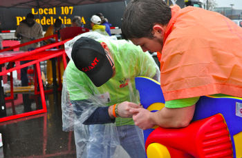 Two Giant employees work in the rain to help assemble Mayfair Memorial Playground. Photo by Kirsten Stamn