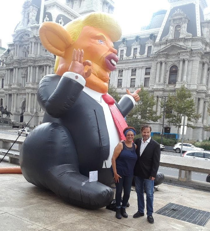 Faye Anderson and John Post Lee in front of the inflatable Trump Rat at Thomas Paine Plaza 
